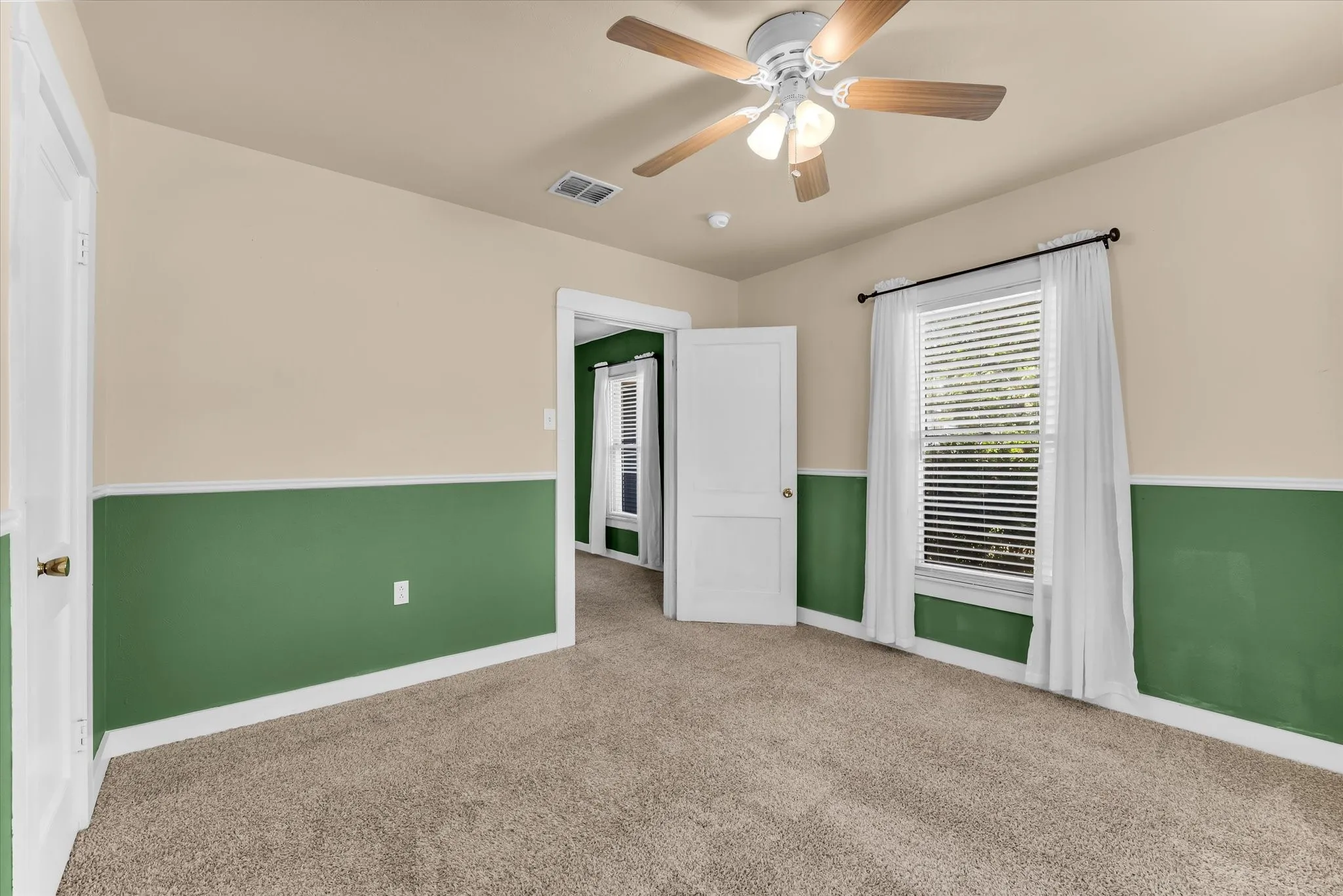 Wall-to-wall carpeting, two-tone painted walls, and white trim throughout