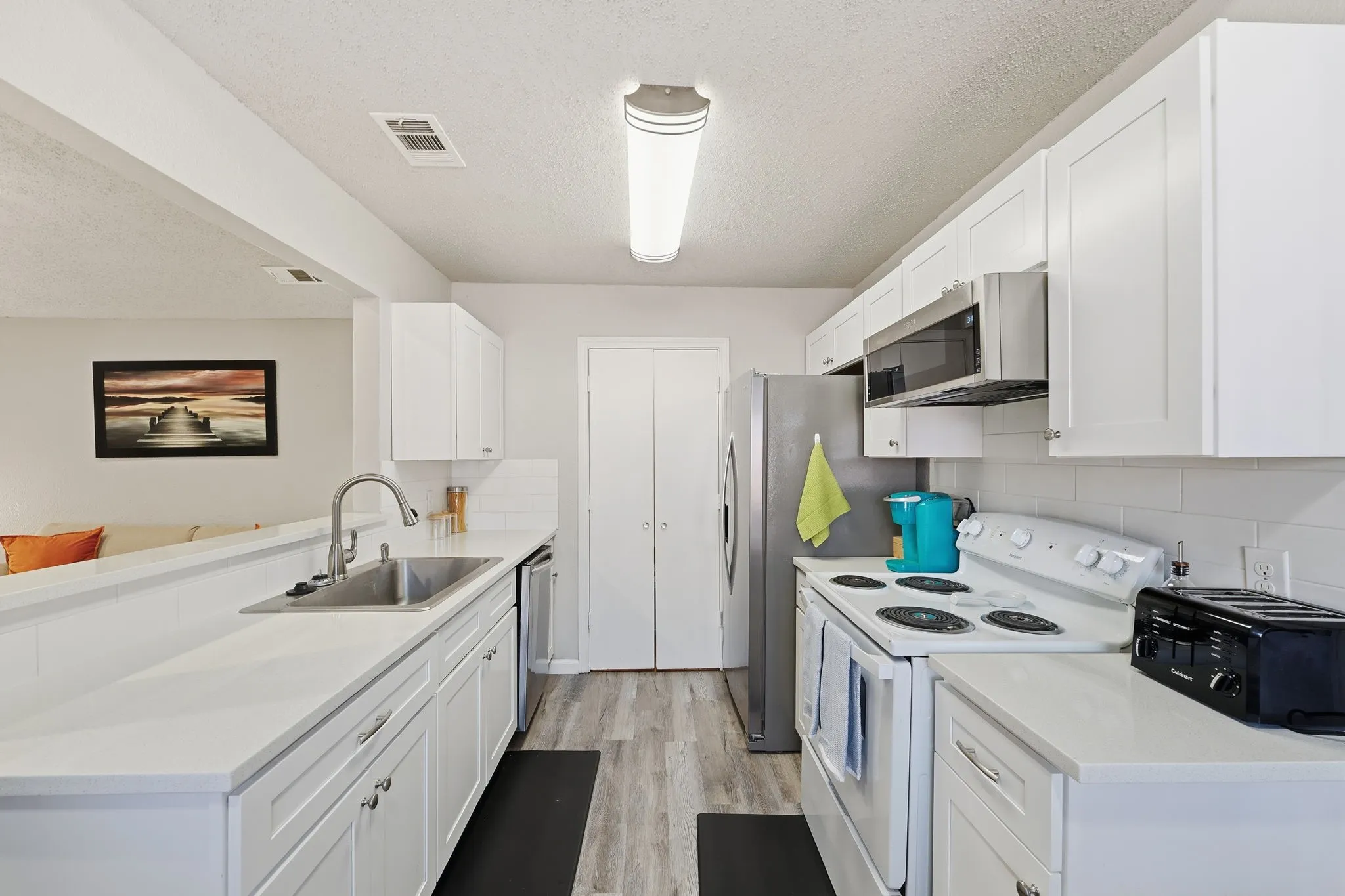 Updated kitchen space and utility room that has the washer and dryer. Fridge, washer, and dryer to stay for new tenant.