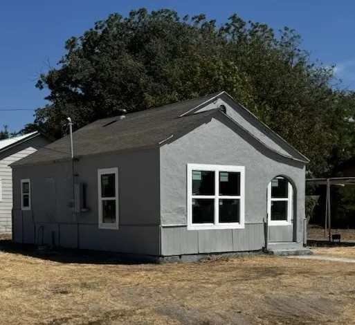 Stucco exterior with a gabled roofline and an arched entryway