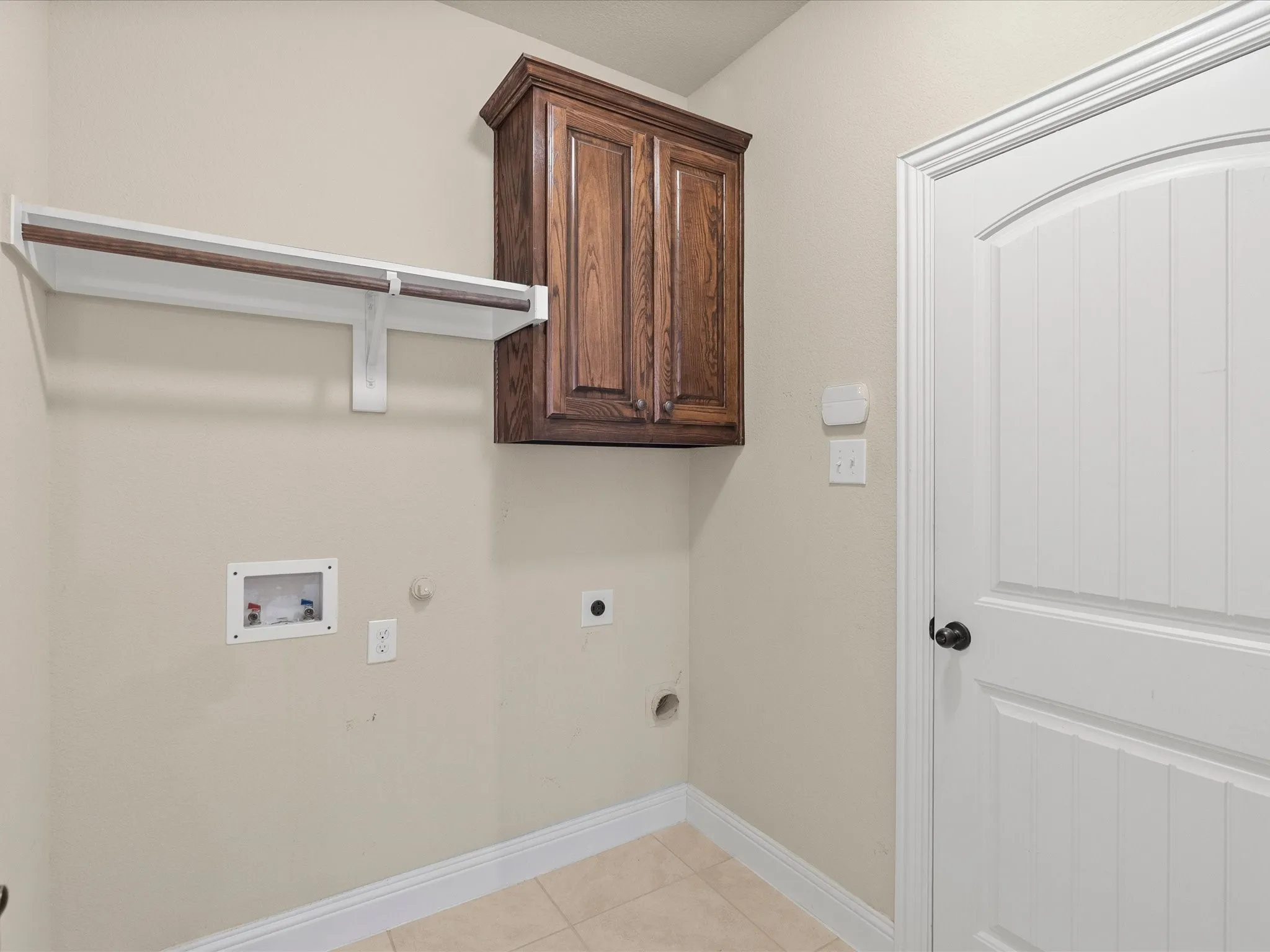 Built-in wood-finish cabinetry, integrated shelving, and a hanging rod