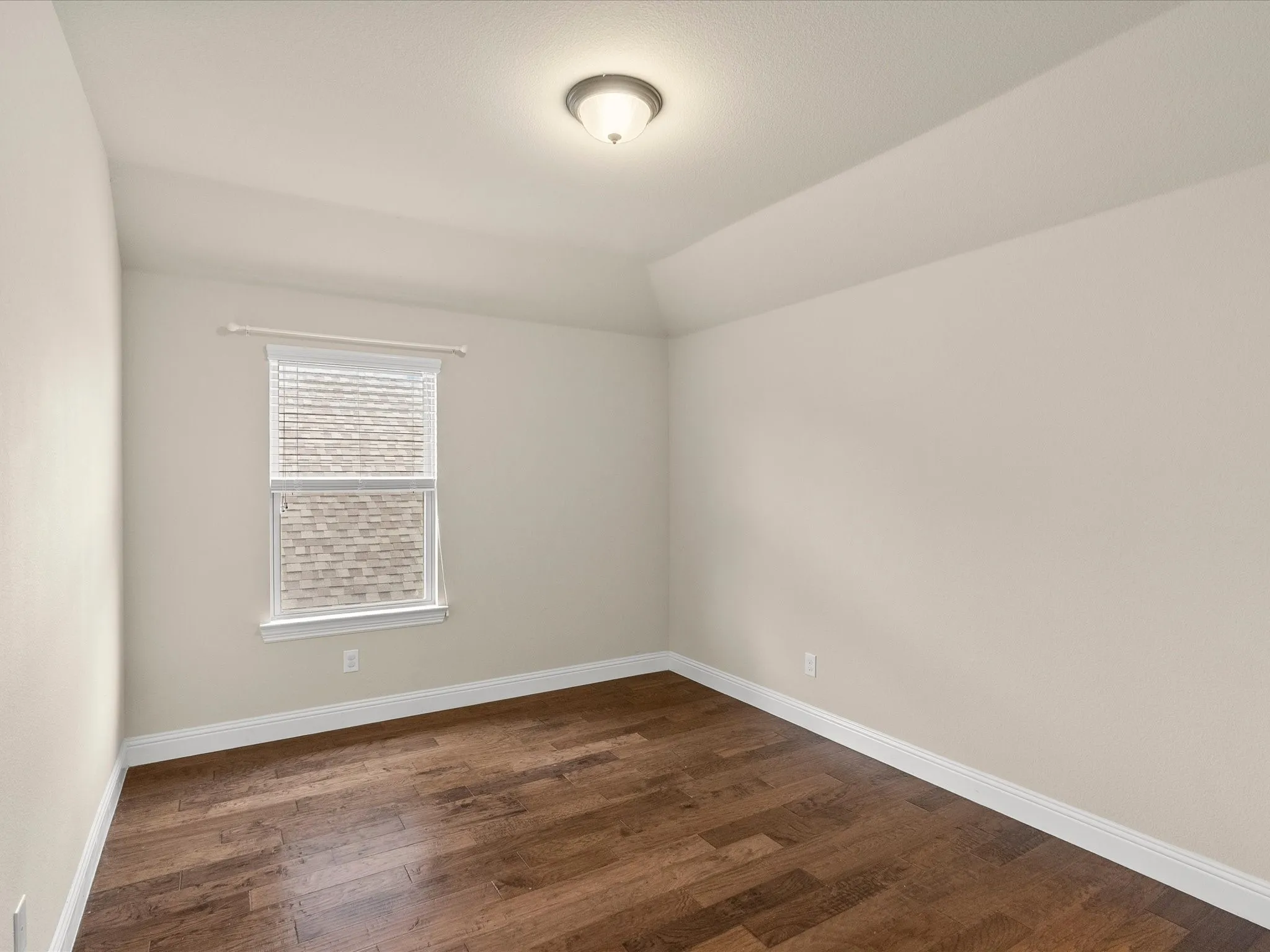 Wood-finish flooring, single window with blinds, ceiling-mounted light fixture, white baseboards, and neutral wall paint