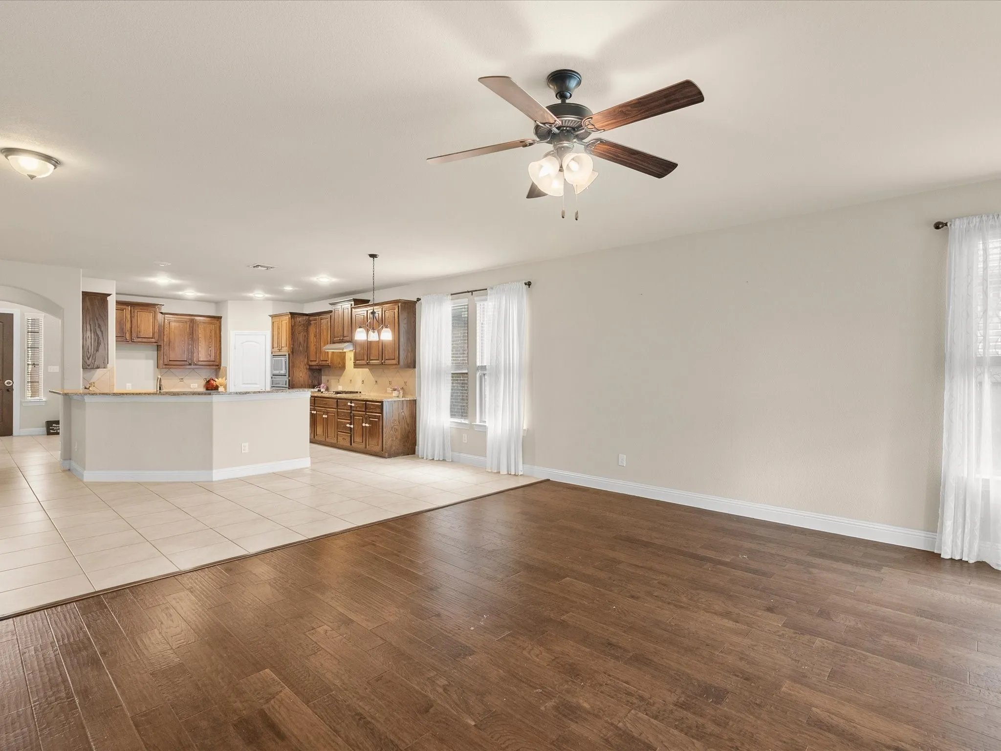 Wood-finish flooring, an overhead ceiling fan, and recessed lighting