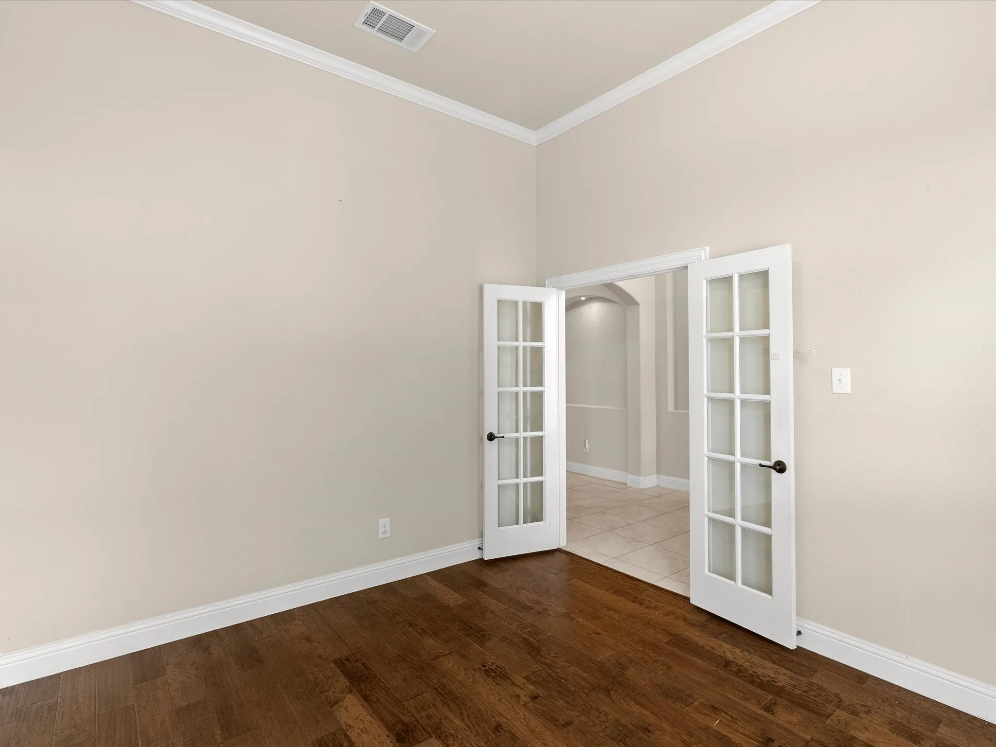 Wood-finish flooring with crown molding and white trim
