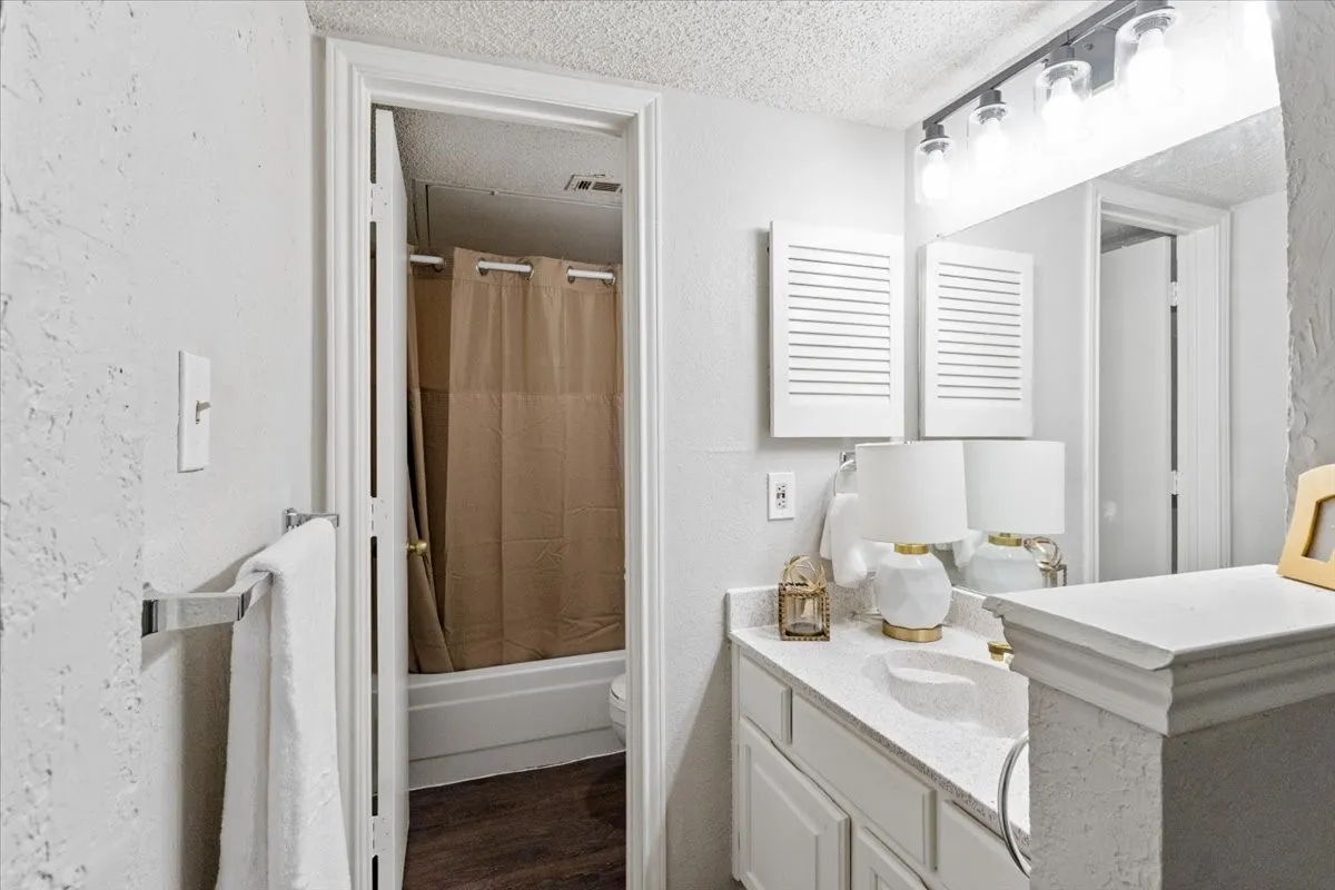 White vanity with a single basin, light-colored countertop, and storage cabinets
