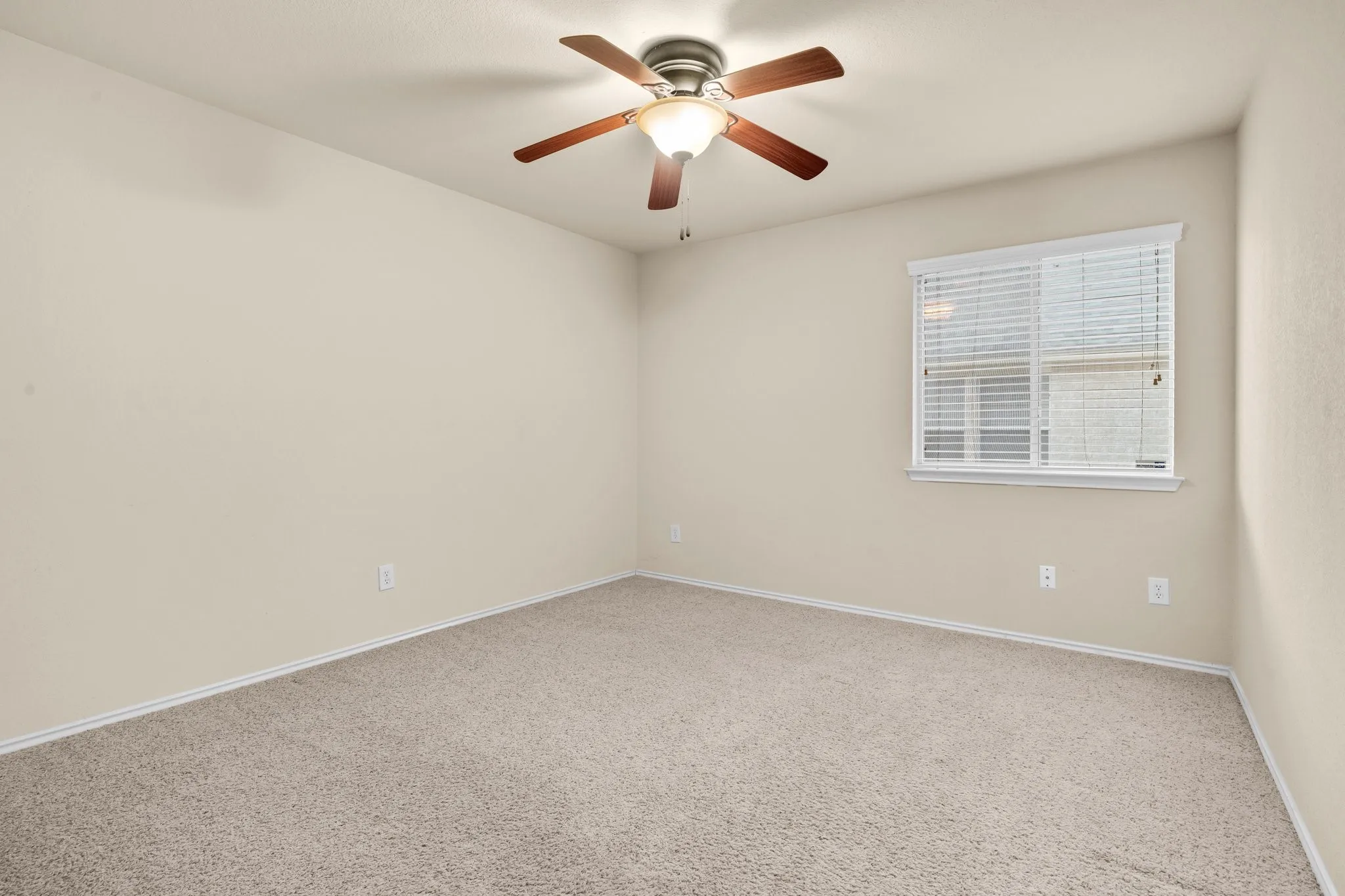 Recessed window with blinds, overhead ceiling fan with lighting, and neutral carpeting
