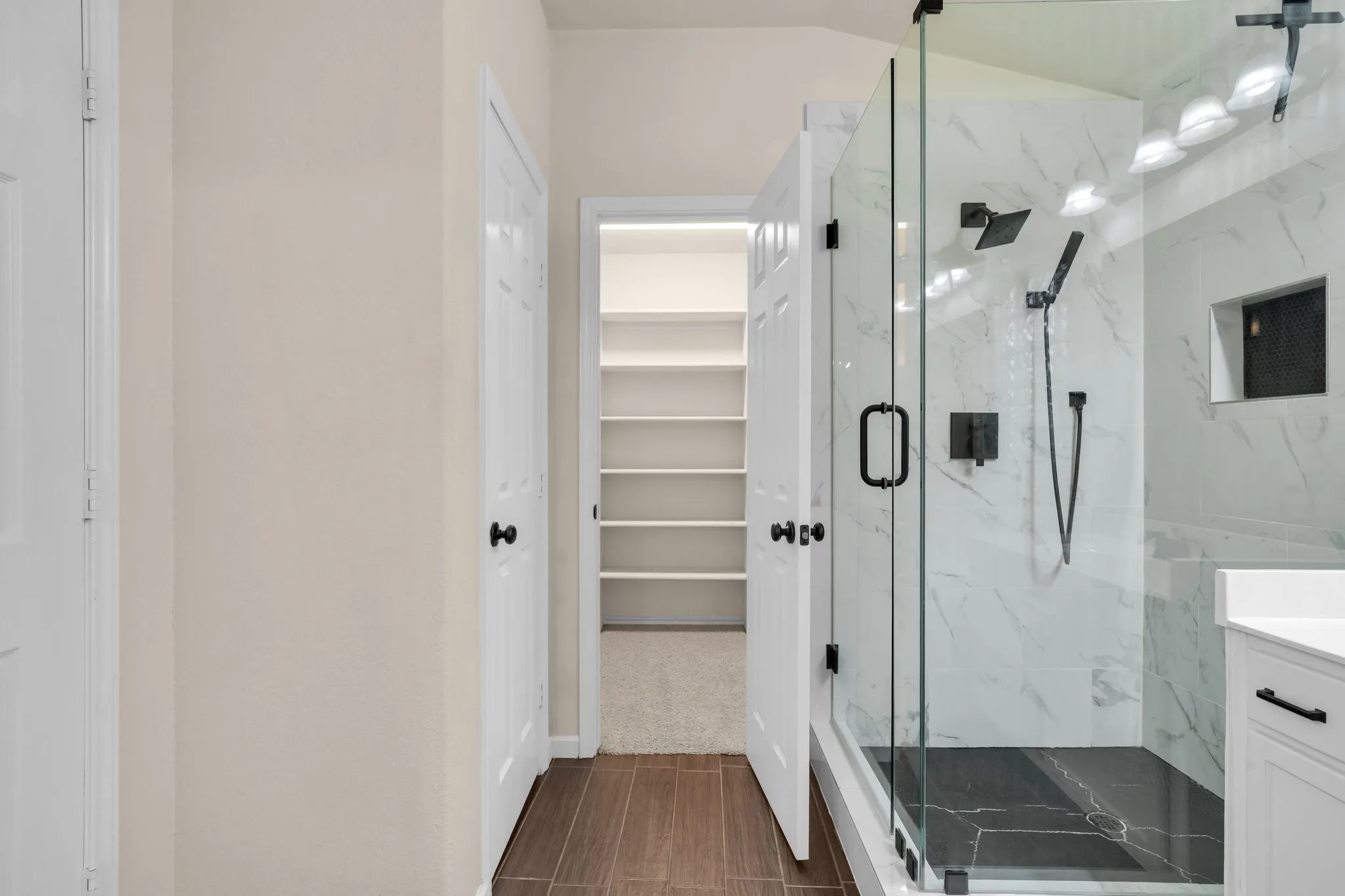 Walk-in shower with clear glass enclosure and matte black fixtures