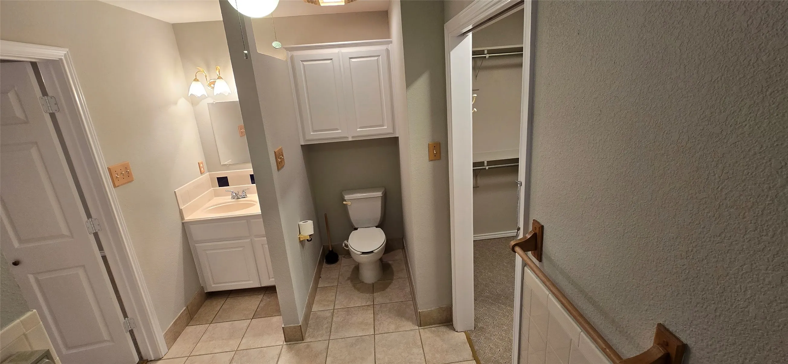 Vanity with integrated sink, overhead lighting, tiled flooring, and built-in cabinetry