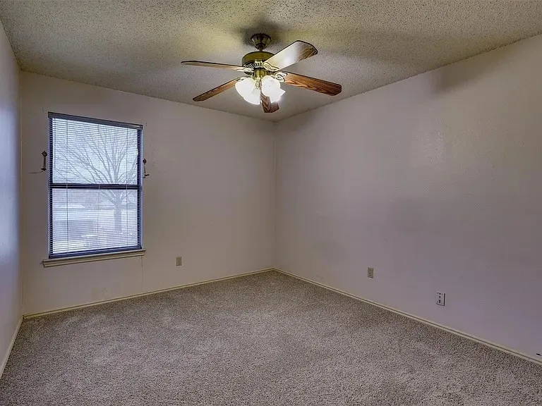 Recessed window featuring blinds, textured ceiling, and a ceiling fan with integrated lighting