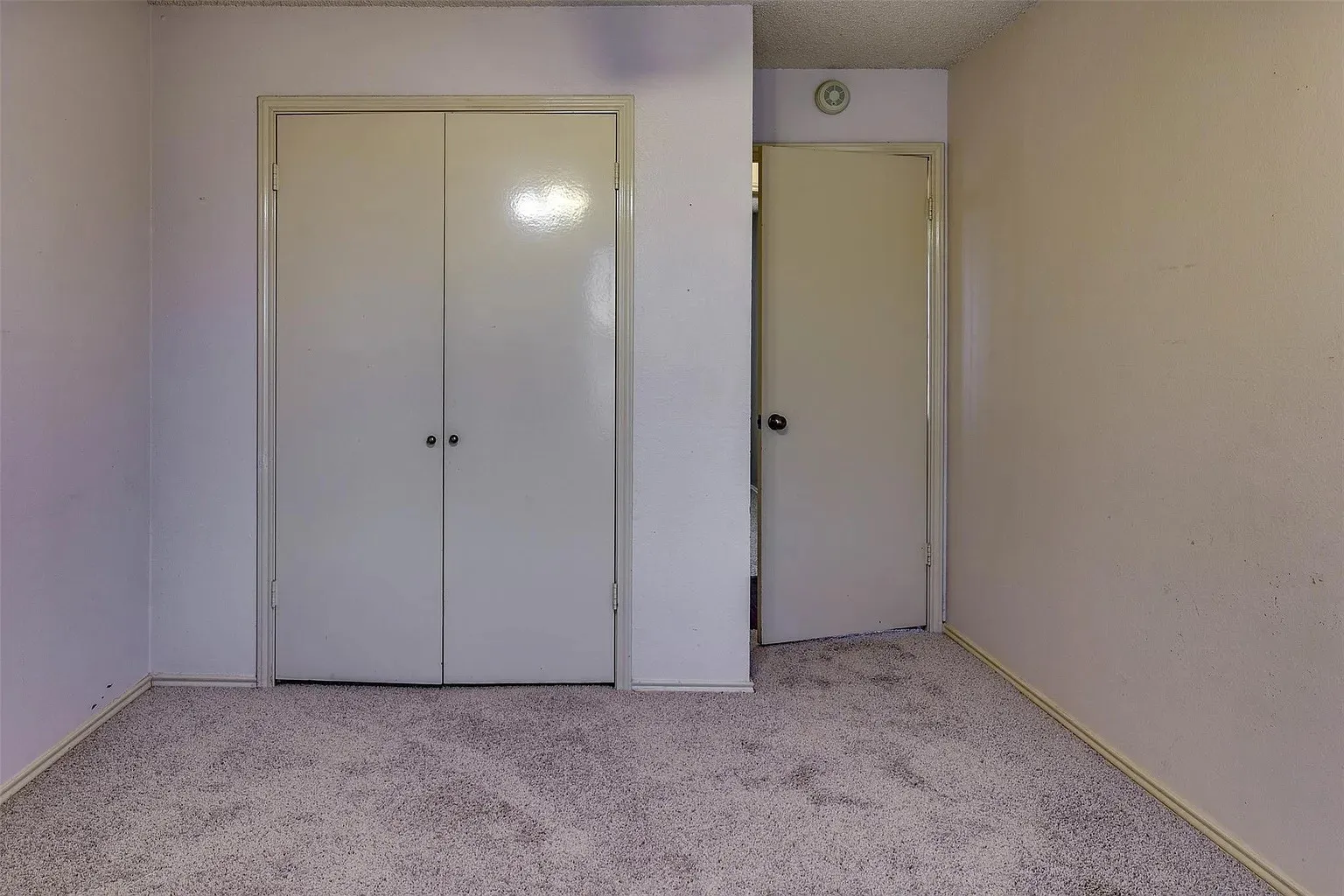 Wall-to-wall carpeting with bi-fold closet doors and an additional interior door