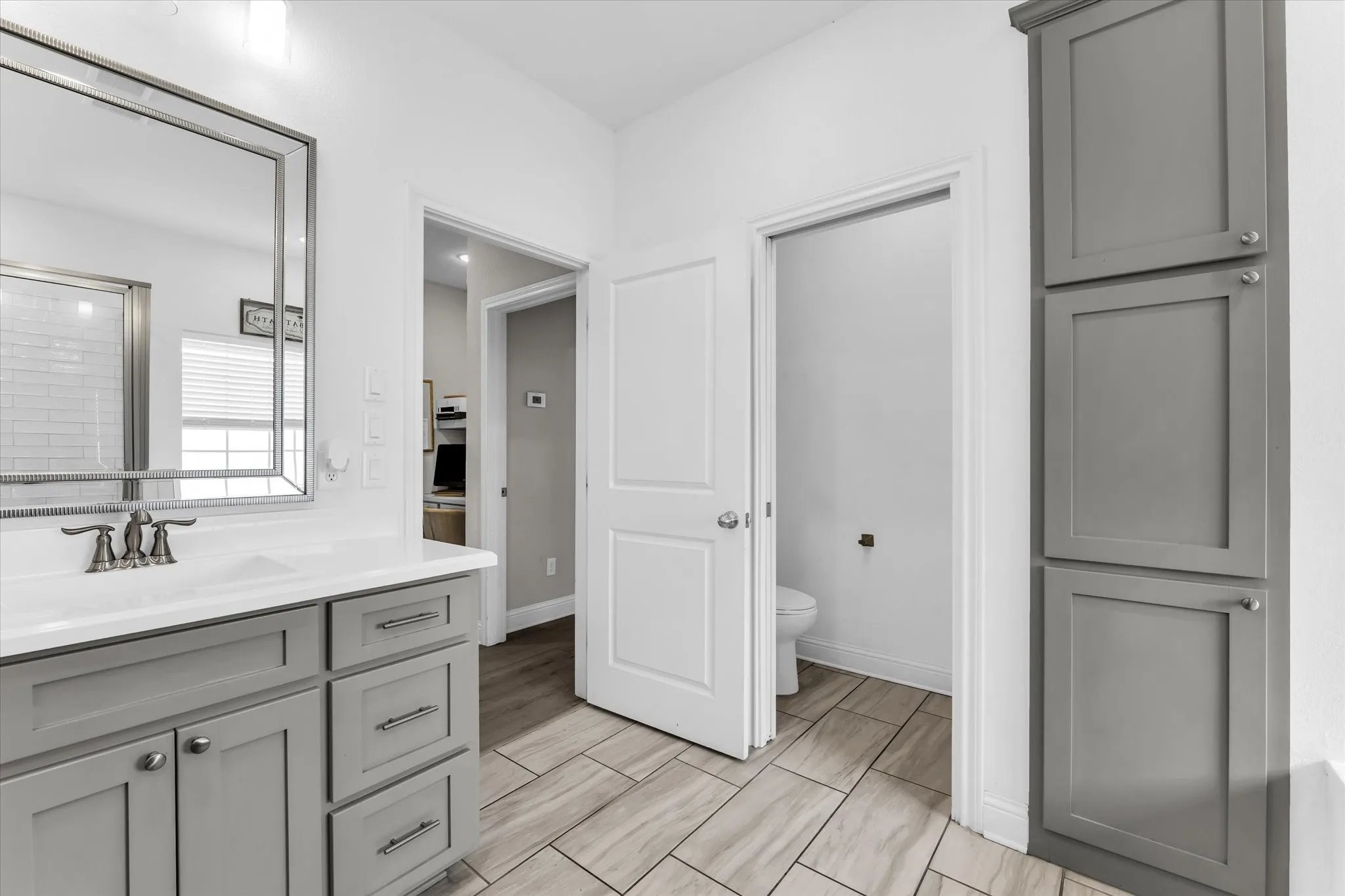 Vanity with light gray cabinetry, a white countertop, and a rectangular undermount sink
