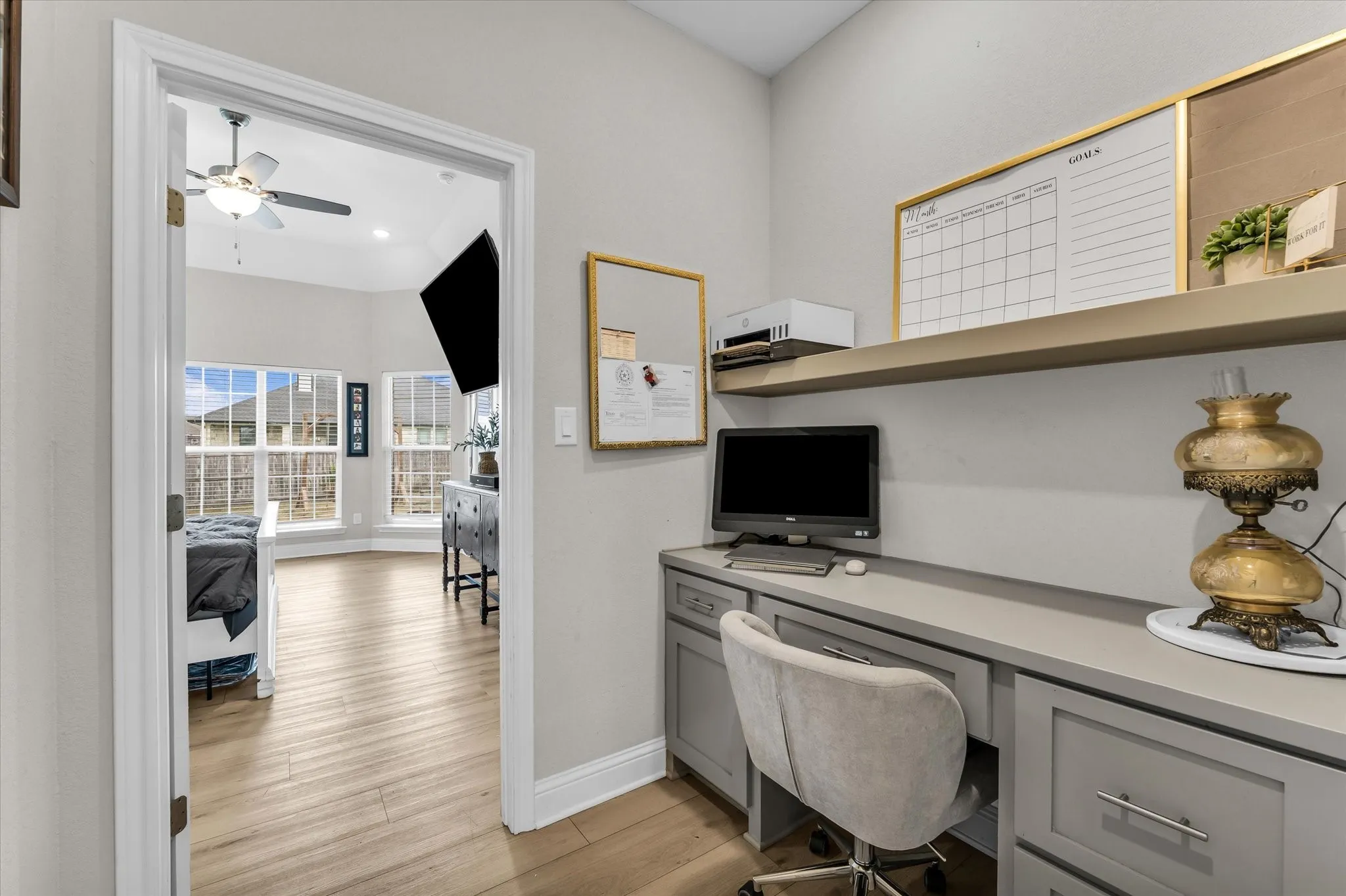 Built-in desk with gray cabinetry and countertop, complemented by an overhead floating shelf