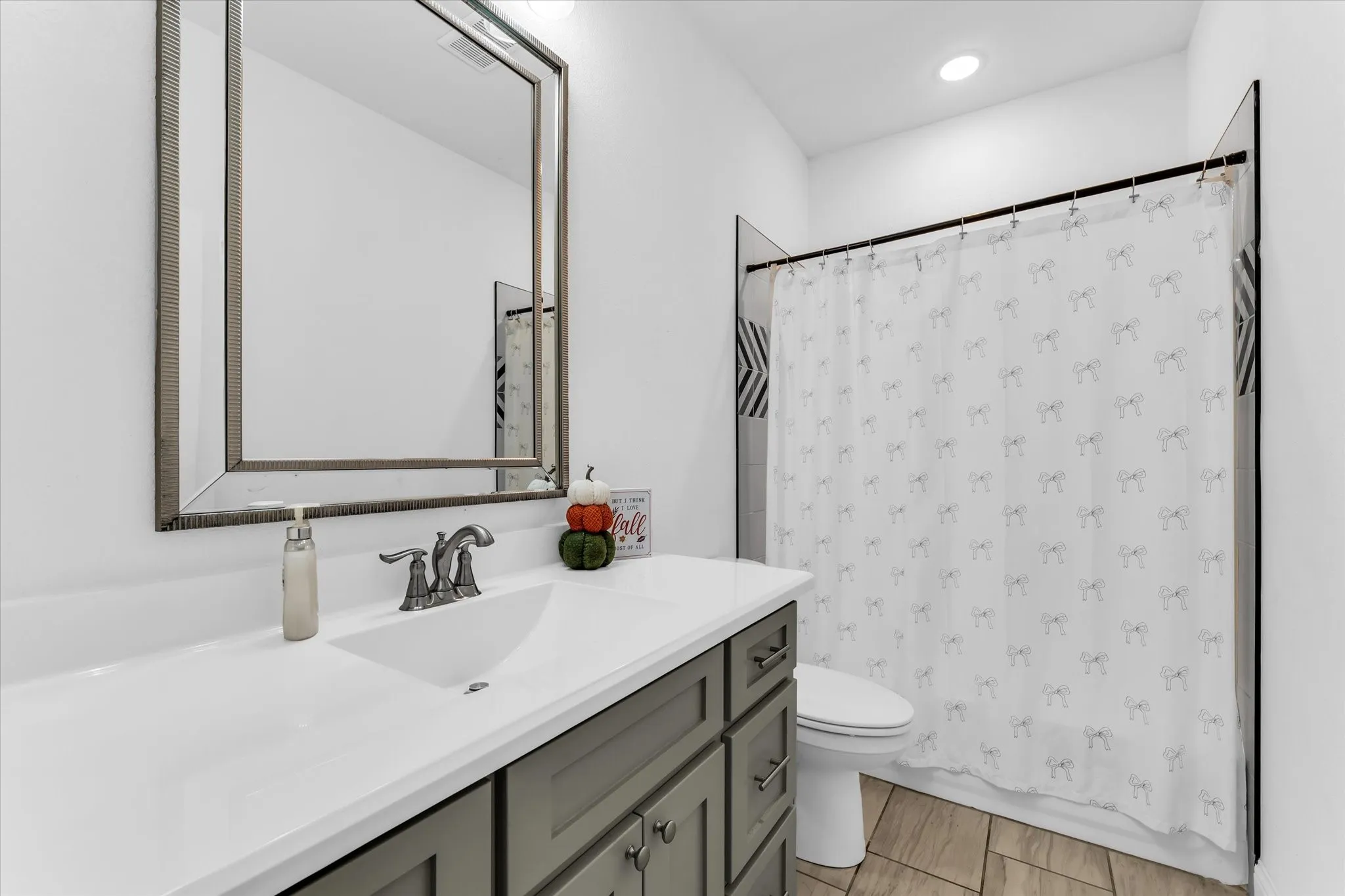 White bathroom vanity with gray cabinetry, a rectangular sink, and a brushed nickel faucet