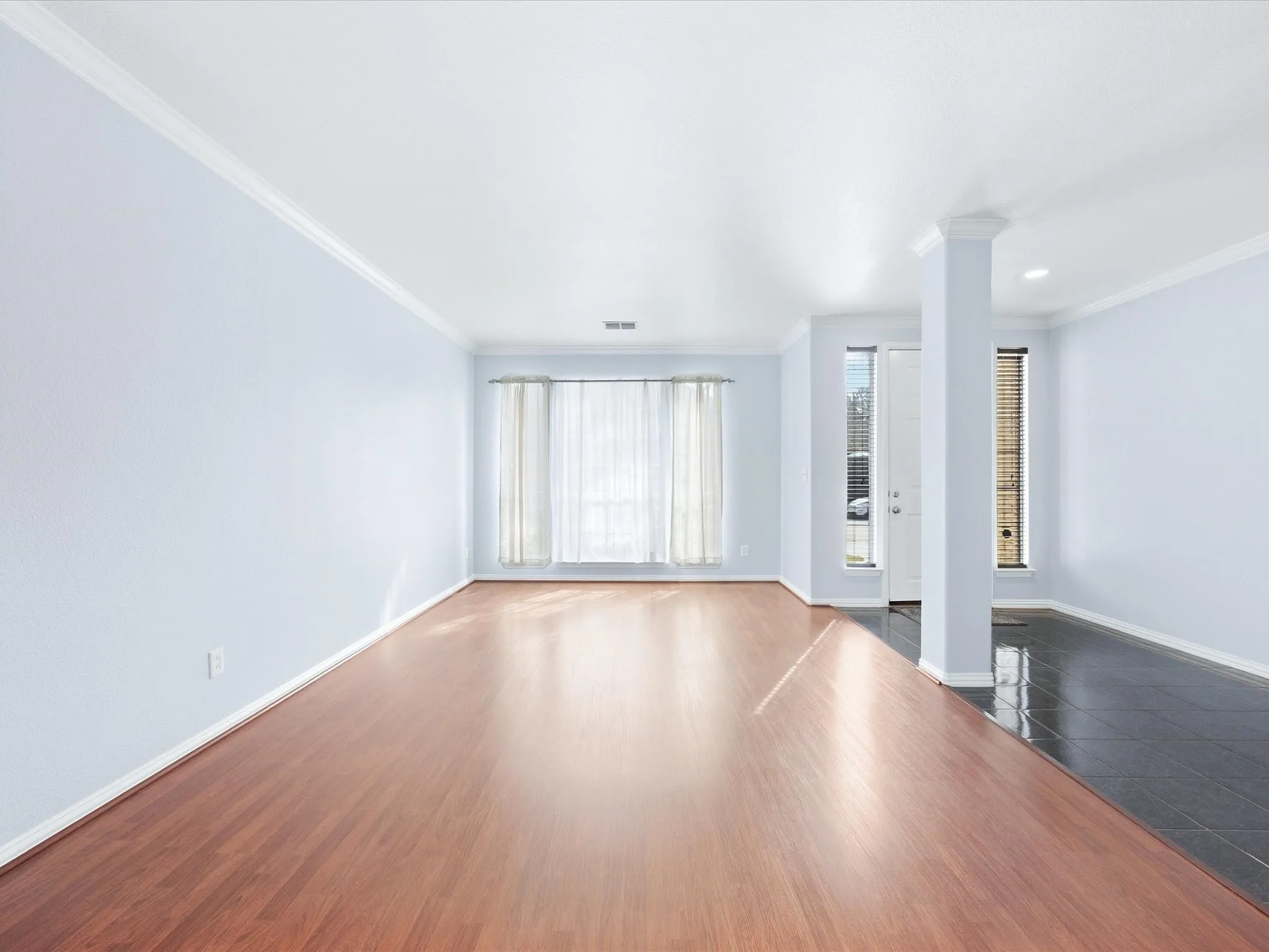 Crown molding throughout, wood-finish flooring, light blue walls, recessed lighting, and a front entry door with side window panels