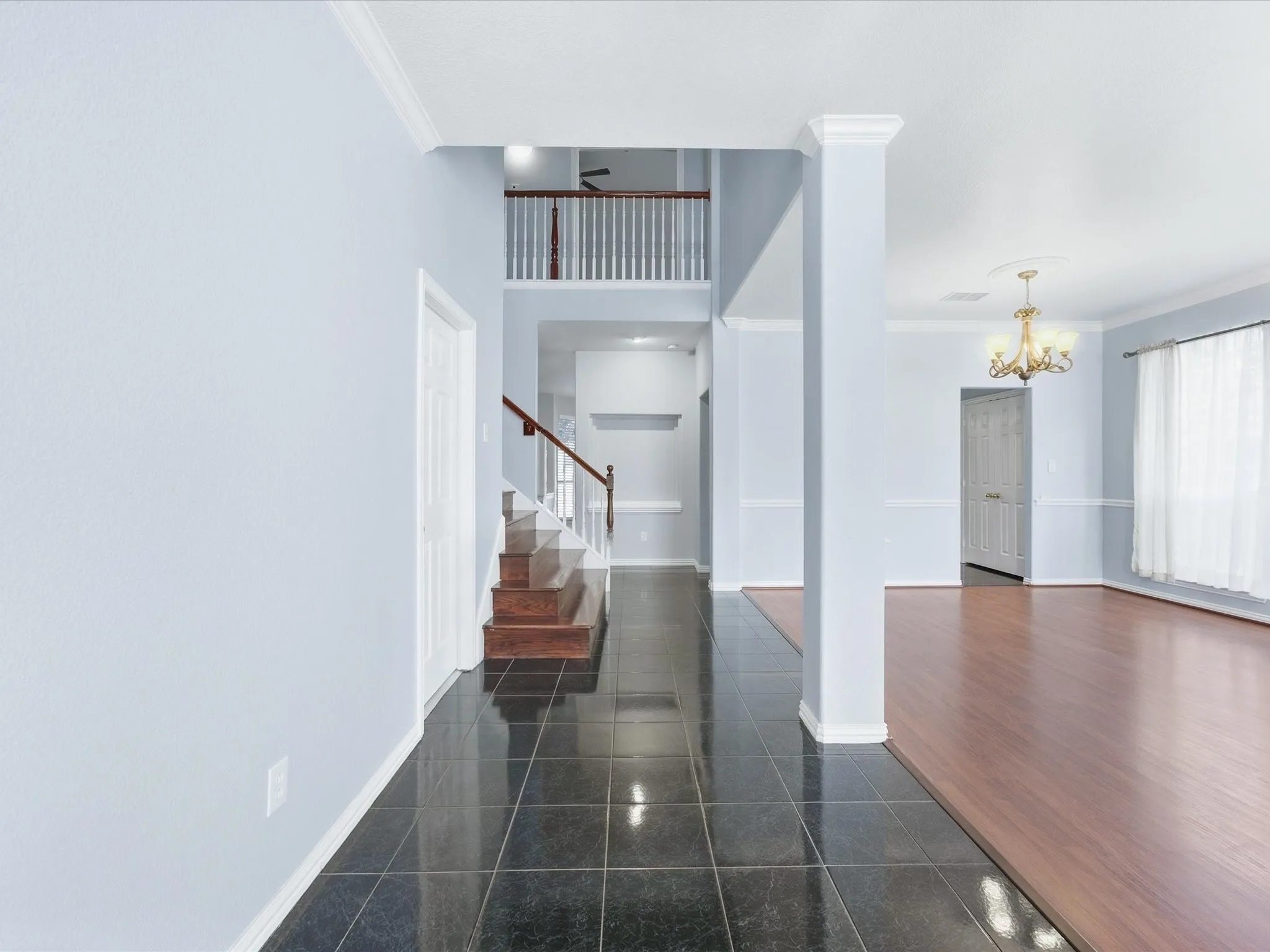 Entryway featuring a staircase, dark tile flooring, and light blue walls