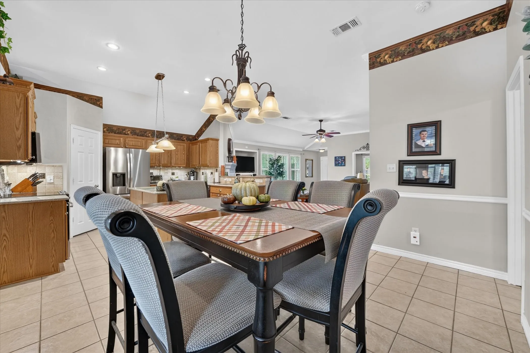 Kitchen and dining area featuring wood cabinetry, stainless steel appliances, and tile flooring