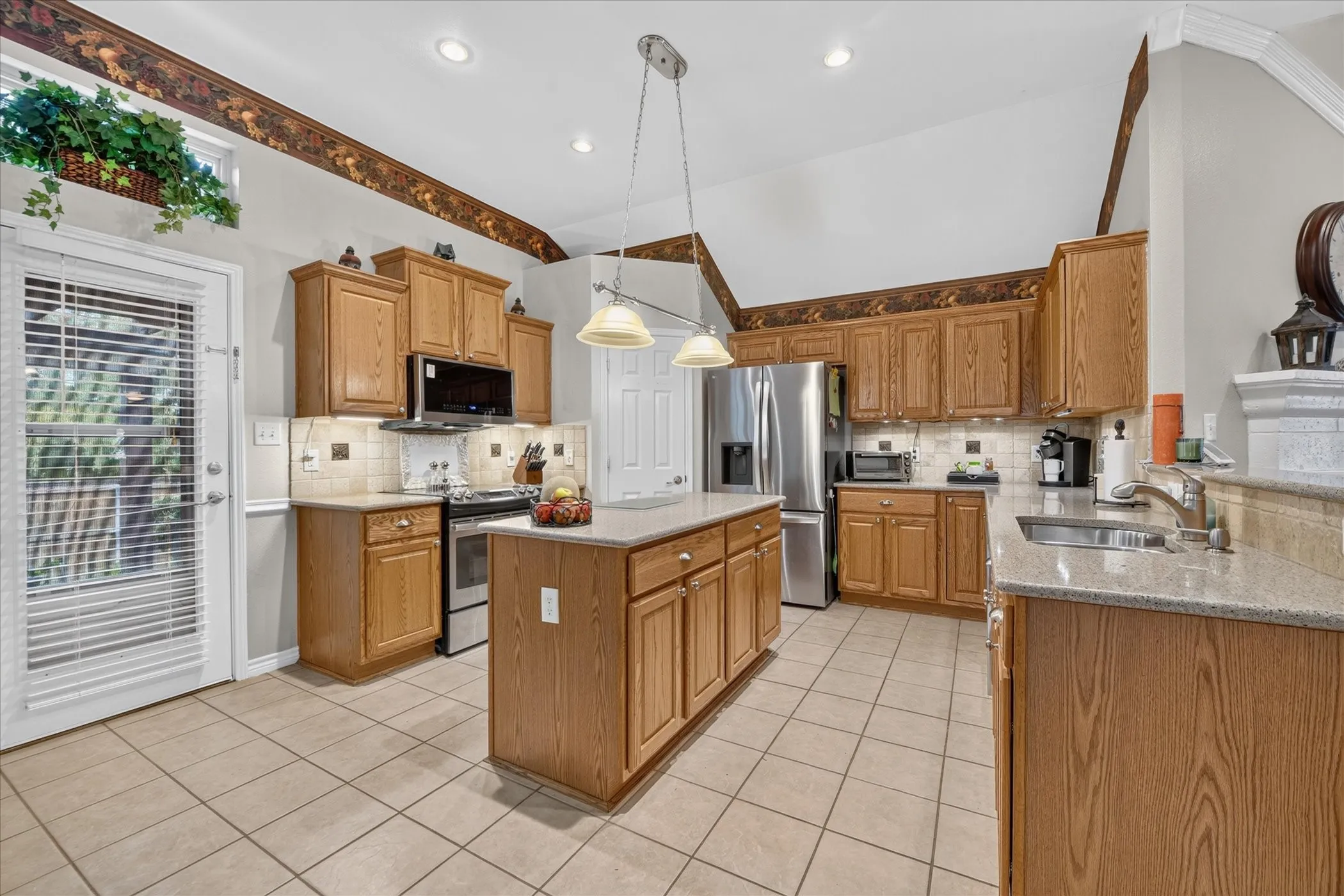 Kitchen featuring wood cabinetry, stainless steel appliances, a center island, recessed lighting, and tile flooring