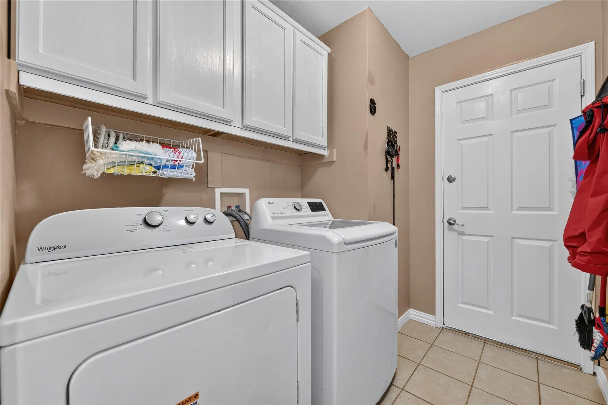 White paneled cabinetry, tiled flooring, and a paneled interior door