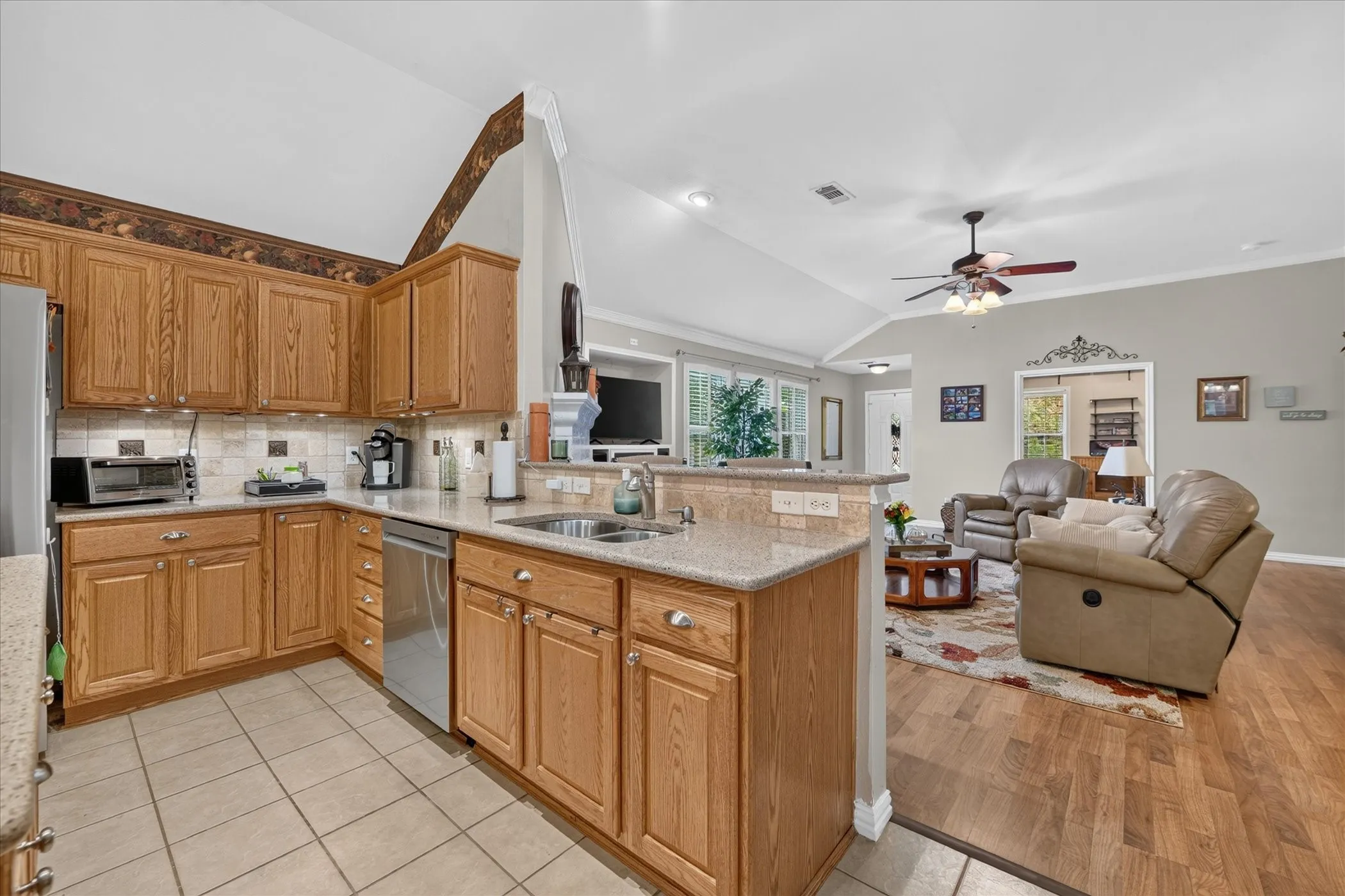 Kitchen featuring wood-finish cabinetry, stainless steel appliances, and tile flooring