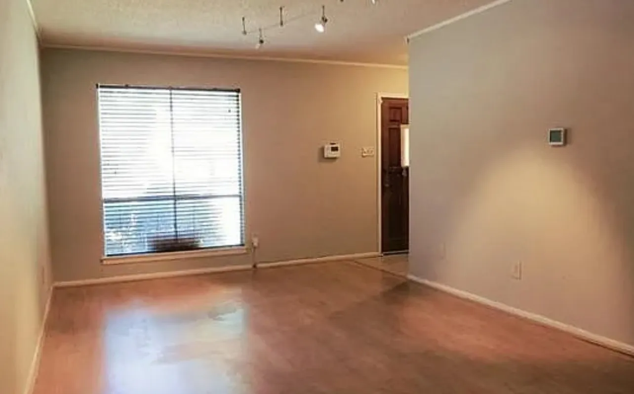Wood-finish flooring throughout, track lighting, and a window with blinds