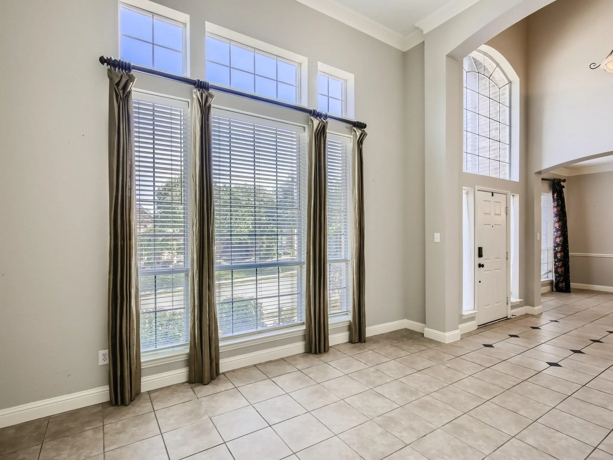 Formal living area with tile flooring, high ceilings