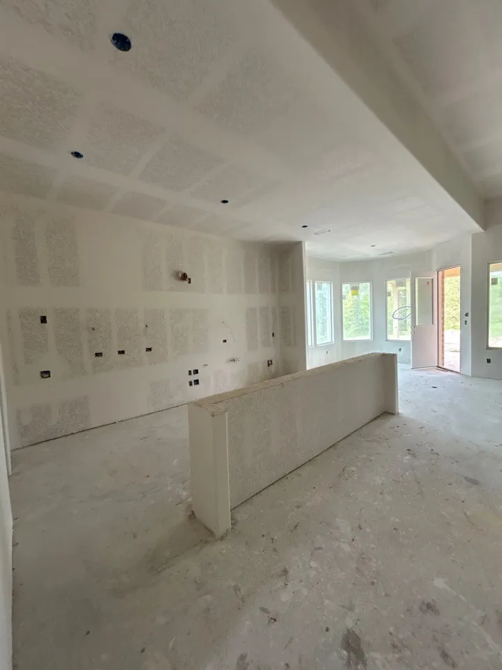 Open-concept space with a partial divider wall, multiple windows, and recessed lighting provisions