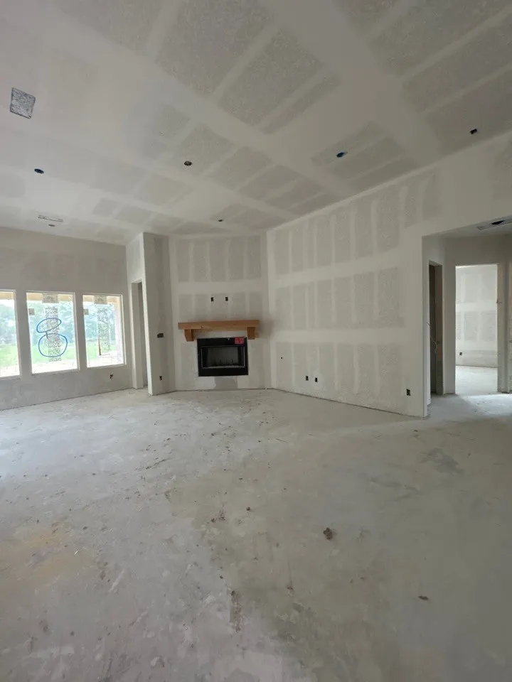 Interior space with unfinished drywall, a fireplace, and multiple windows