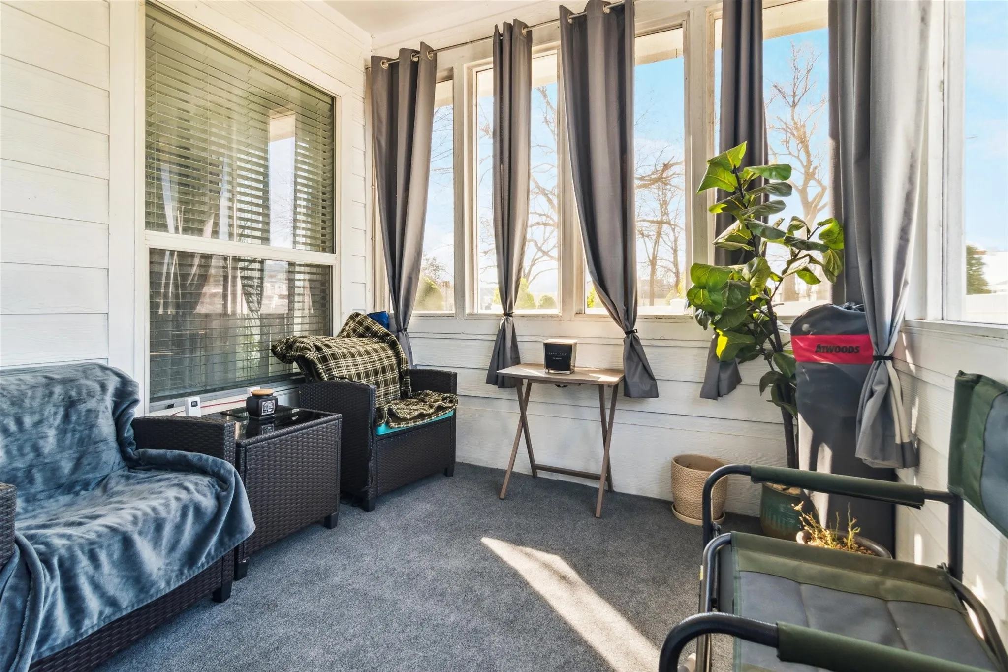 Enclosed porch with carpet flooring and multiple windows