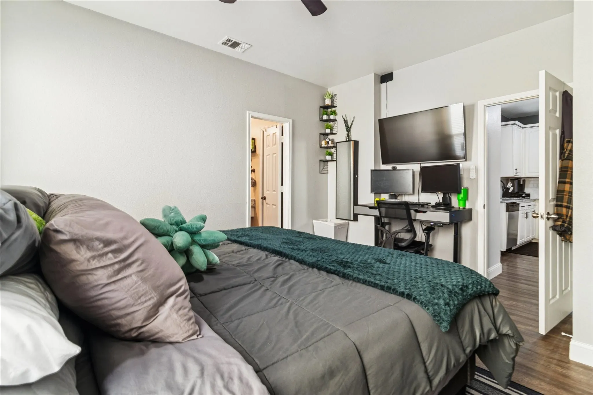 Wood-finish flooring, white paneled doors, and a ceiling fan with integrated lighting