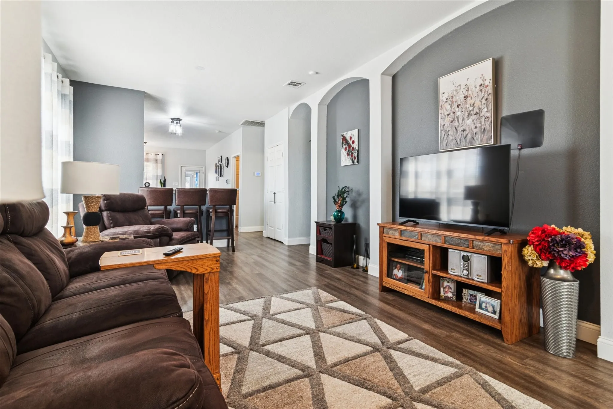 Wood-finish flooring throughout, complemented by arched wall cut-outs and neutral wall tones