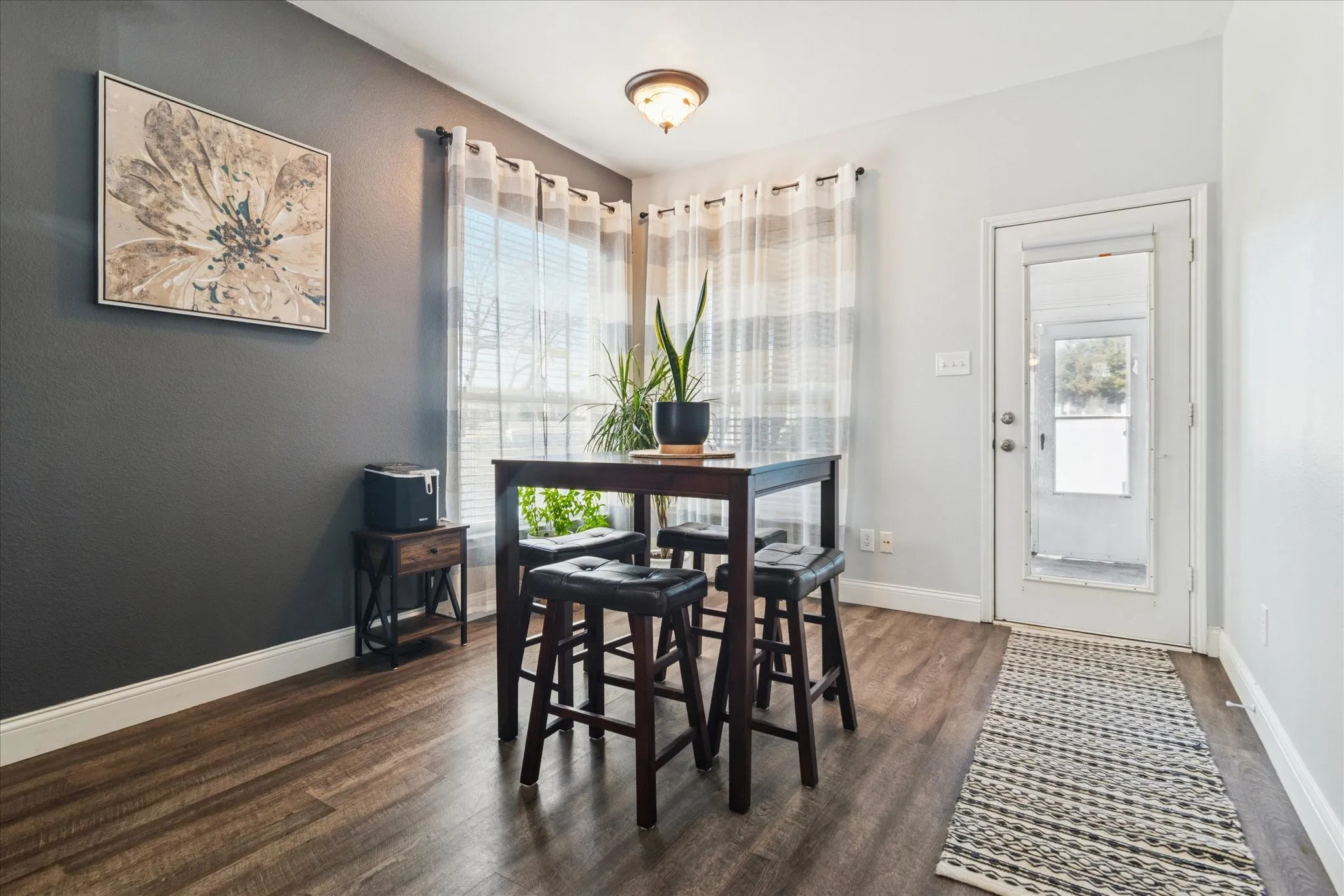 Wood-finish flooring throughout, two-tone wall paint, white trim, and a full-light exterior door