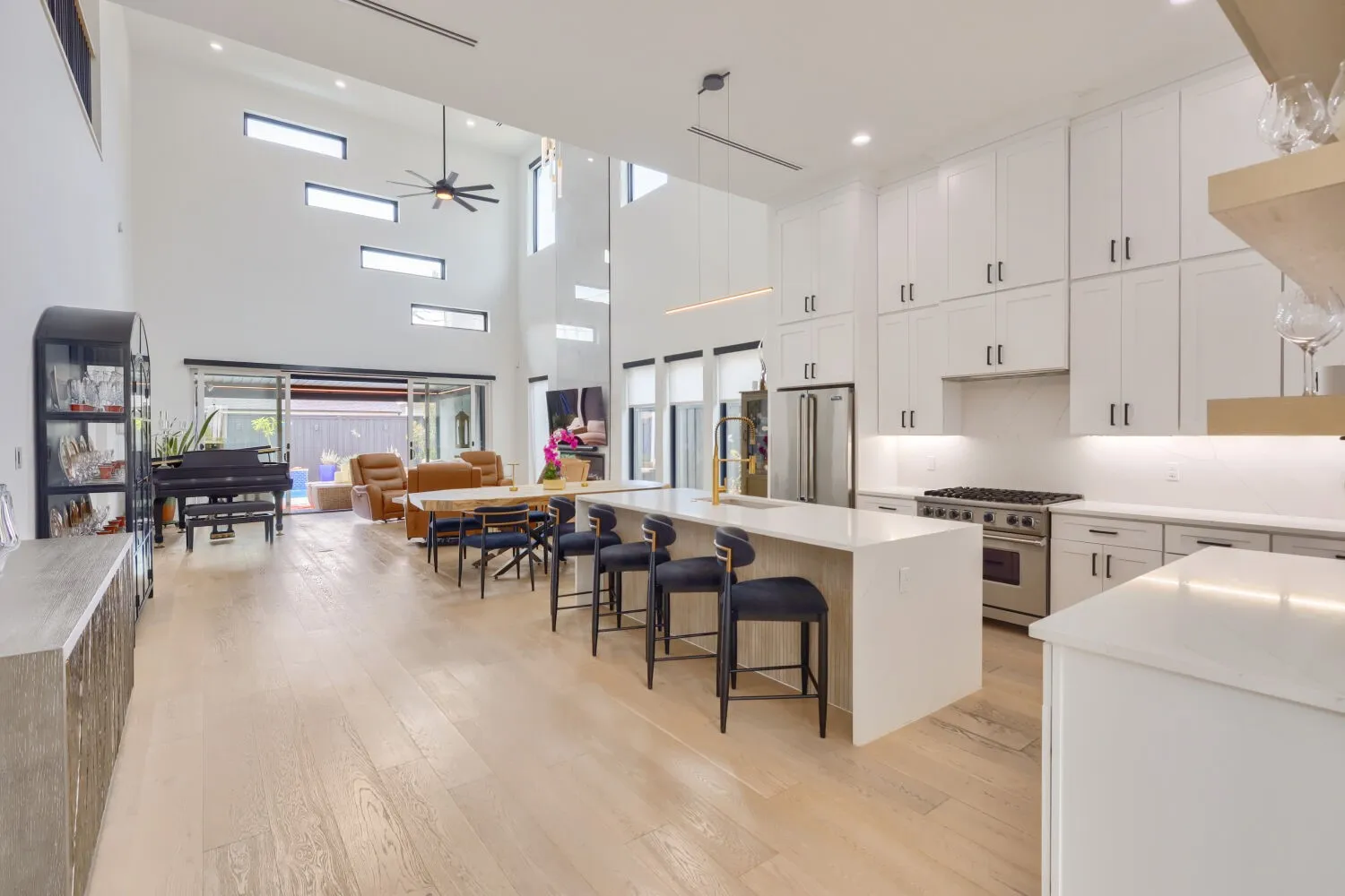 Expansive open-concept living space with high ceilings and wood-finish flooring