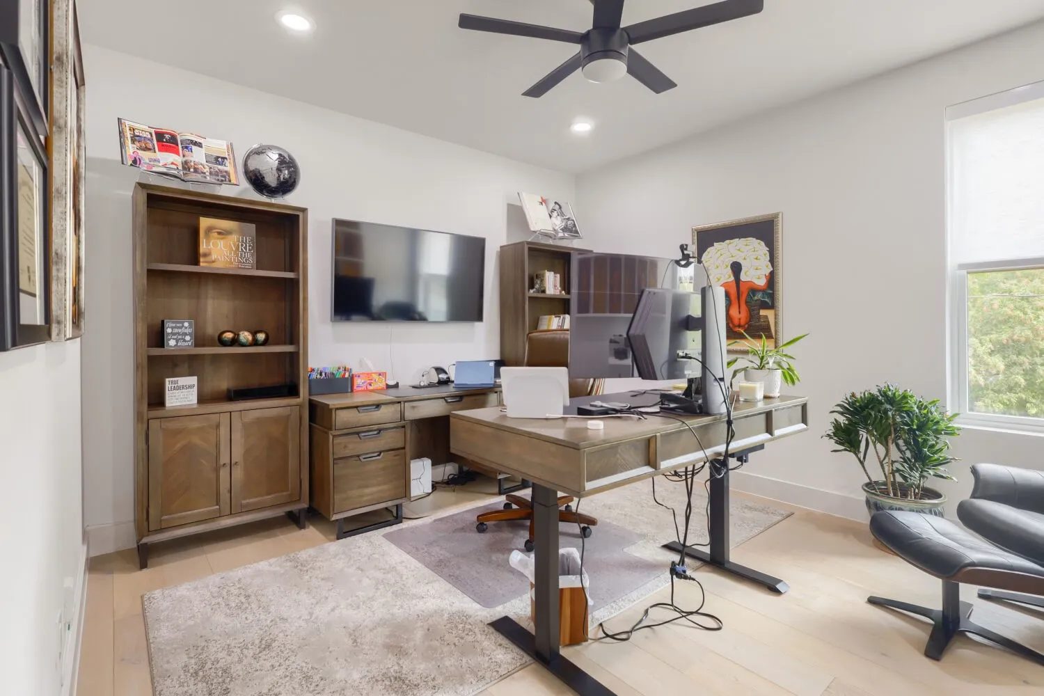 Set Up as working from home office - Recessed lighting, light wood-finish flooring, ceiling fan, large window, and built-in shelving unit