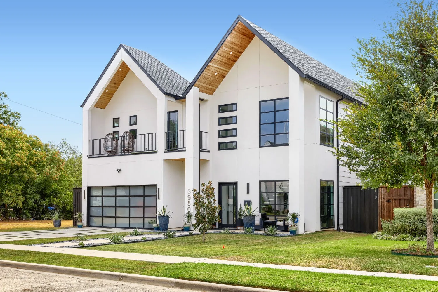 Contemporary two-story residence with a prominent gabled roofline and wood-finish eaves