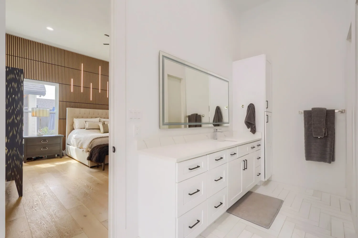 White vanity with ample storage, integrated sink, and illuminated mirror