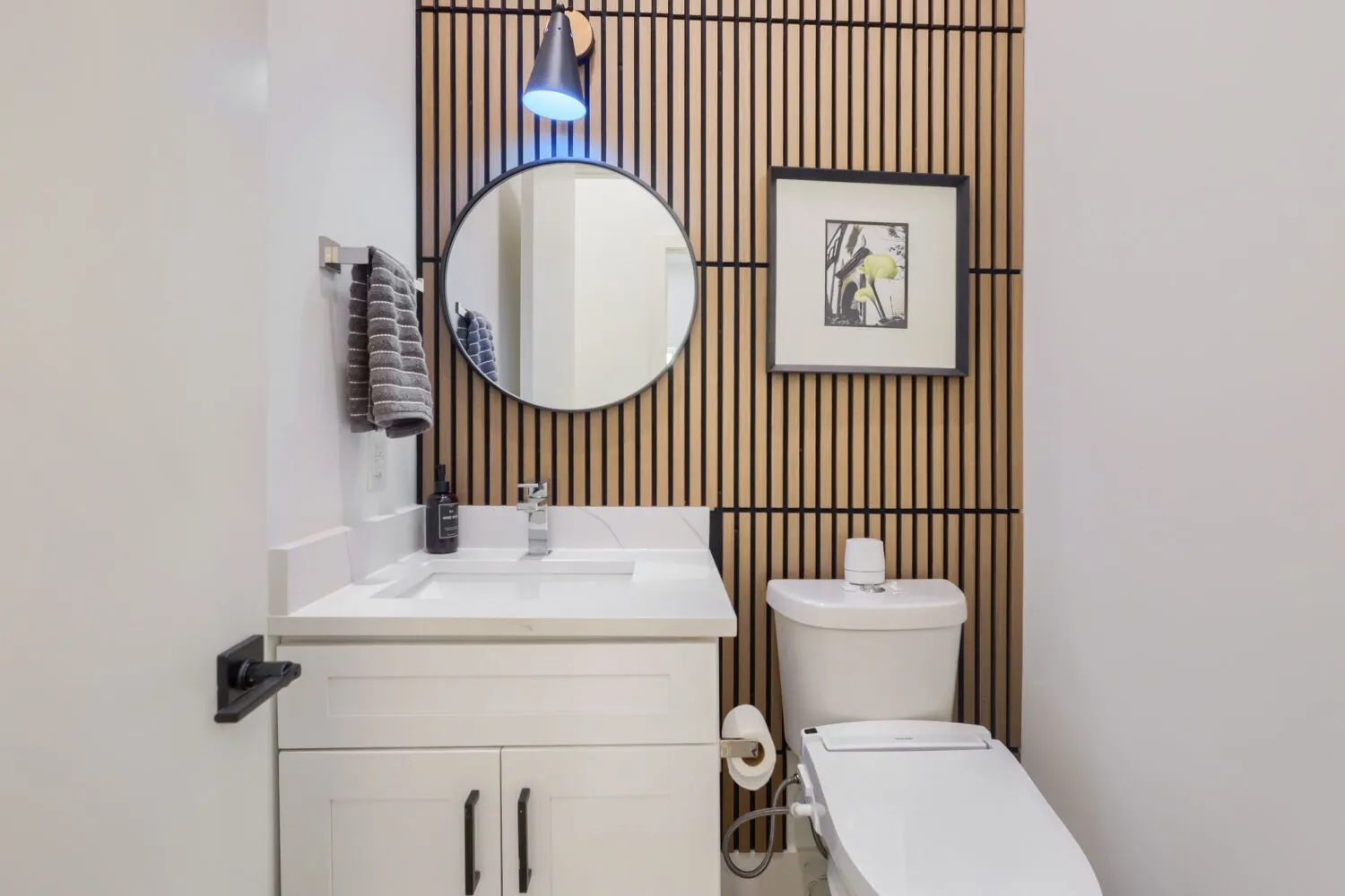 White vanity with shaker-style cabinetry, a quartz countertop, and a rectangular undermount sink