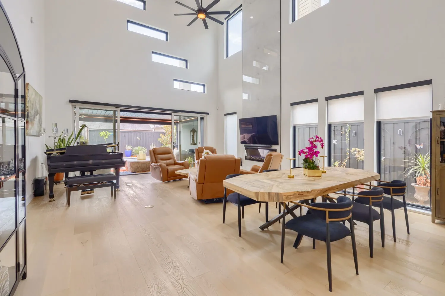Soaring ceilings with transom windows, wood-finish flooring, and an integrated fireplace feature