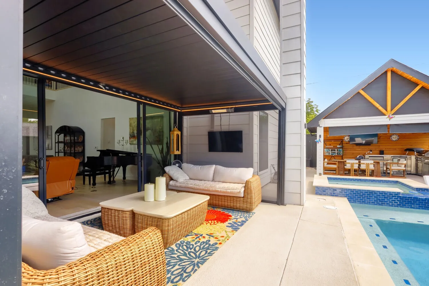 Expansive concrete patio with a full outdoor kitchen, built-in swimming pool, and dedicated spa