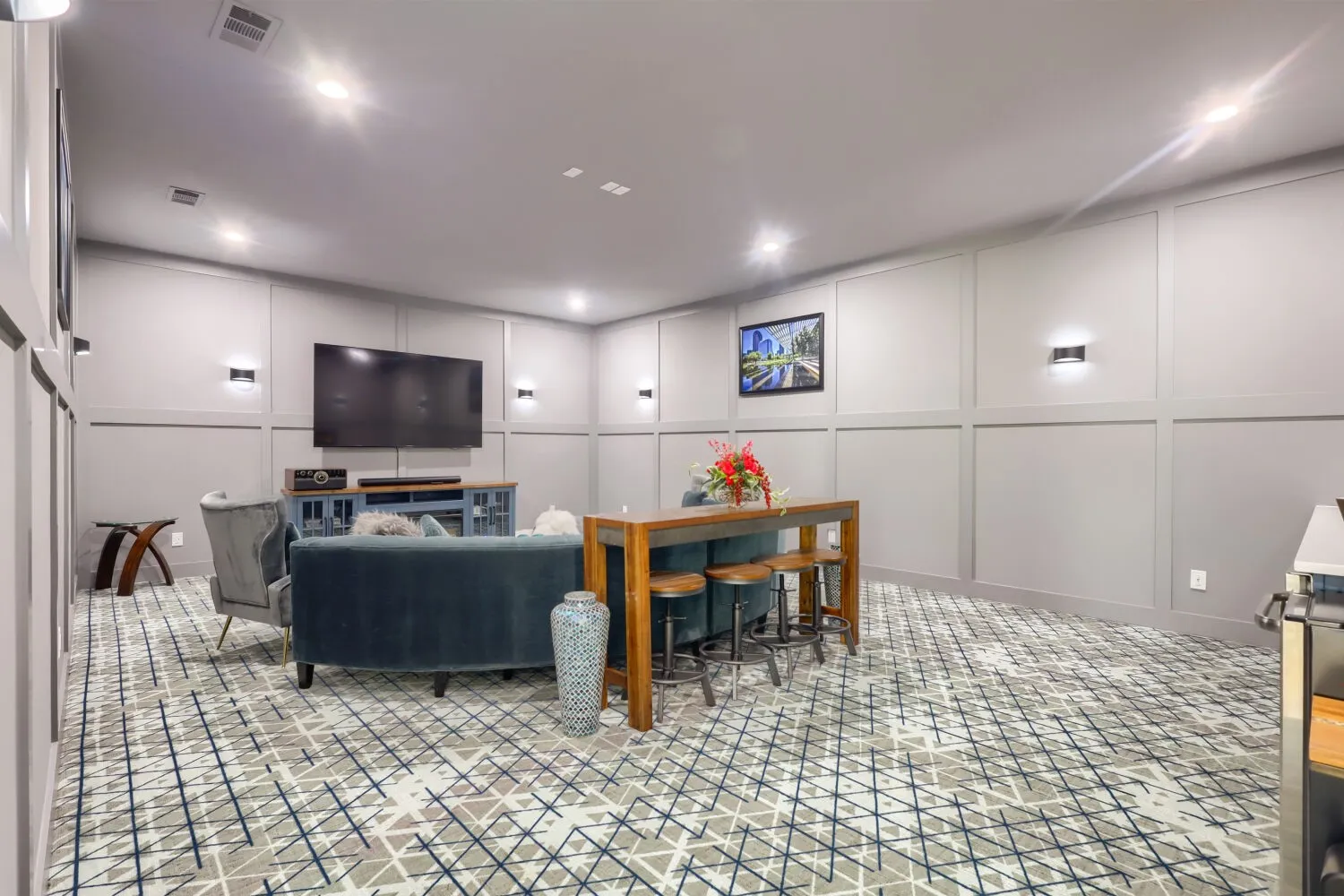 Recessed ceiling lighting, wainscoting paneling, patterned wall-to-wall carpeting, and wall sconces