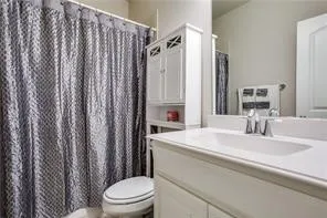 White vanity with an integrated rectangular sink, chrome faucet, and expansive mirror