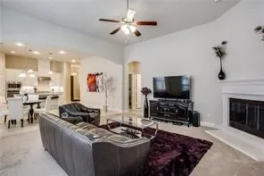 Vaulted ceiling, ceiling fan, built-in fireplace, recessed lighting, and an archway