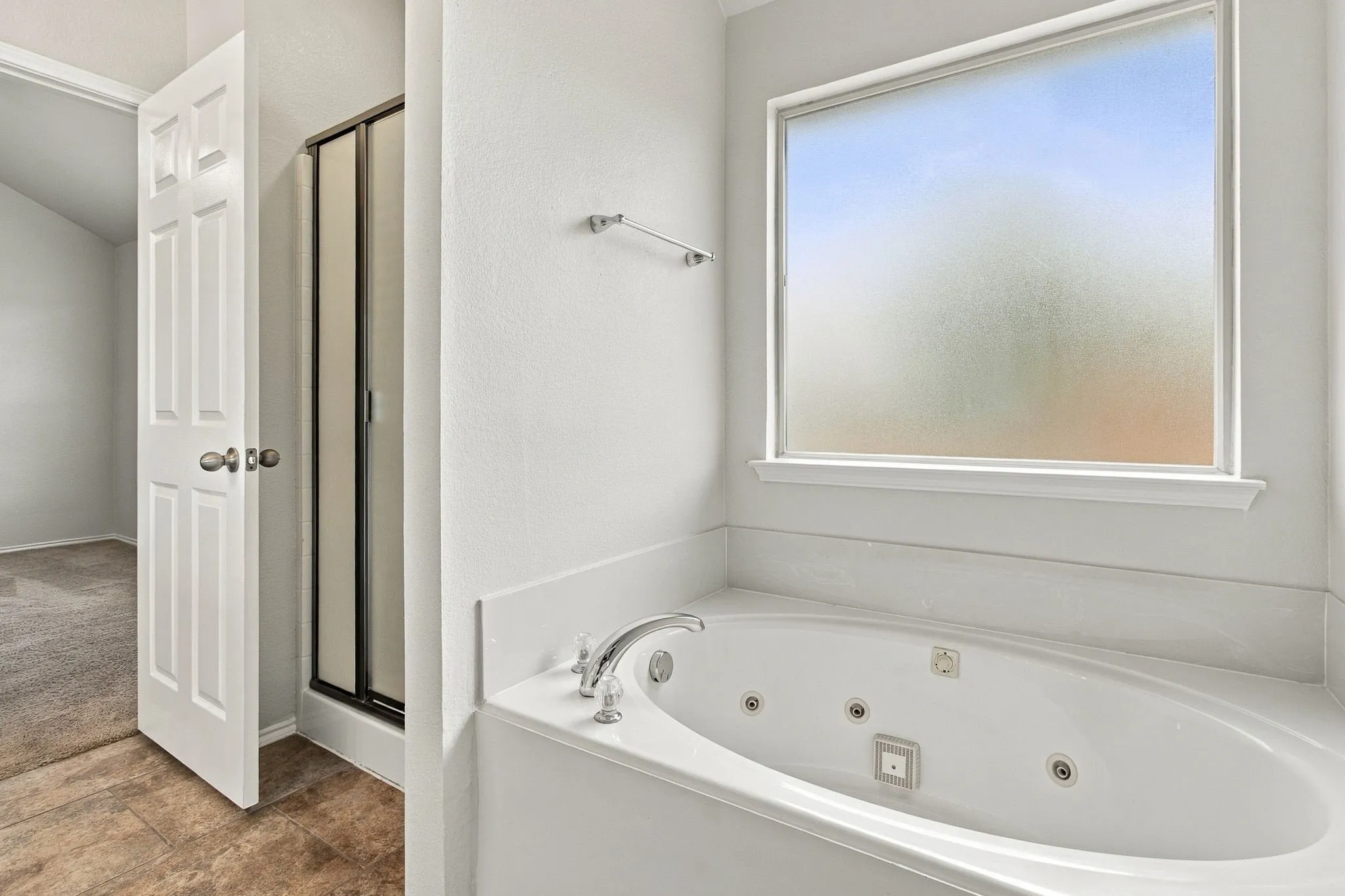 Soaking tub with integrated jets and deck-mounted polished chrome fixtures
