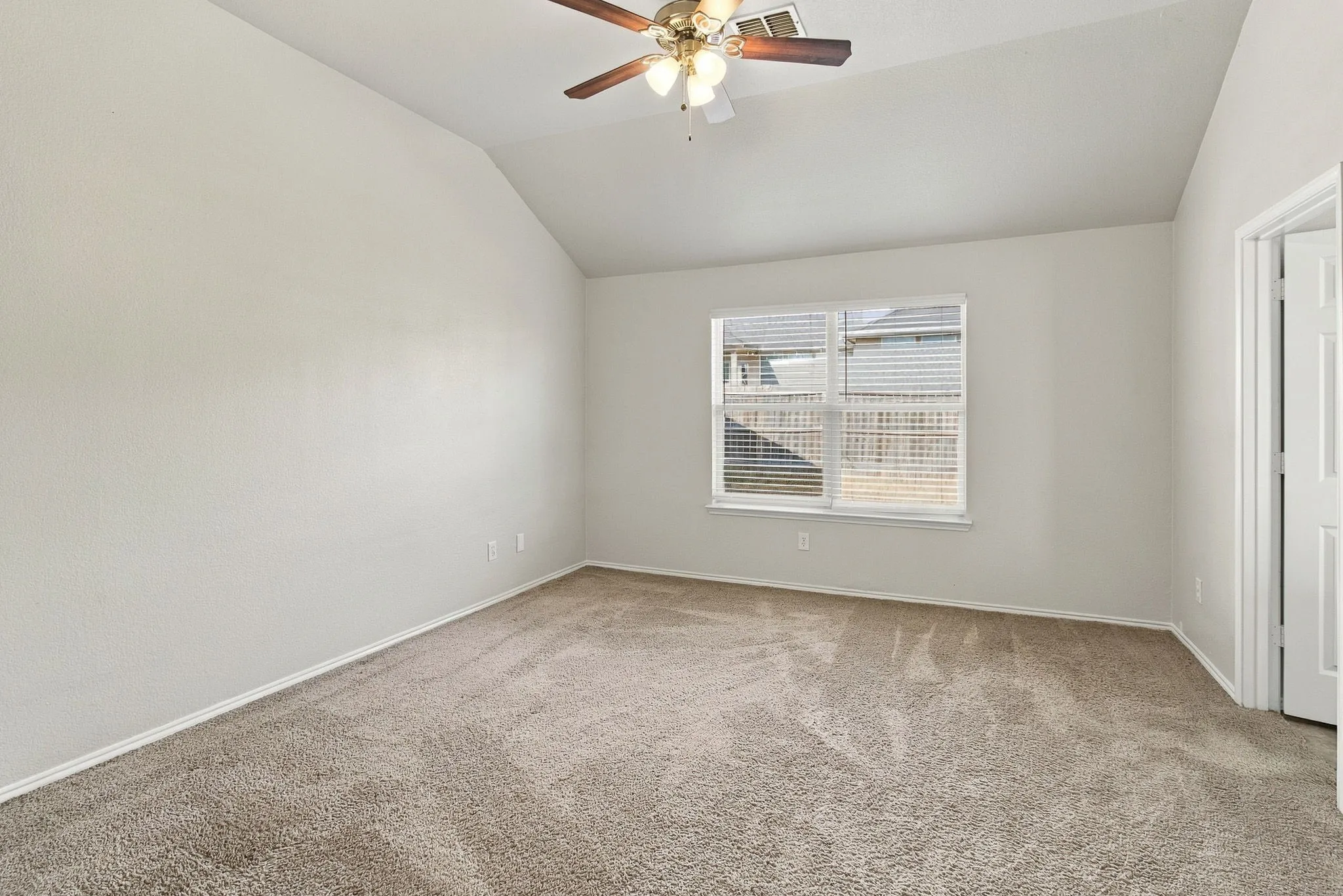 Vaulted ceiling, ceiling fan, window with blinds, carpeted flooring, and white painted walls