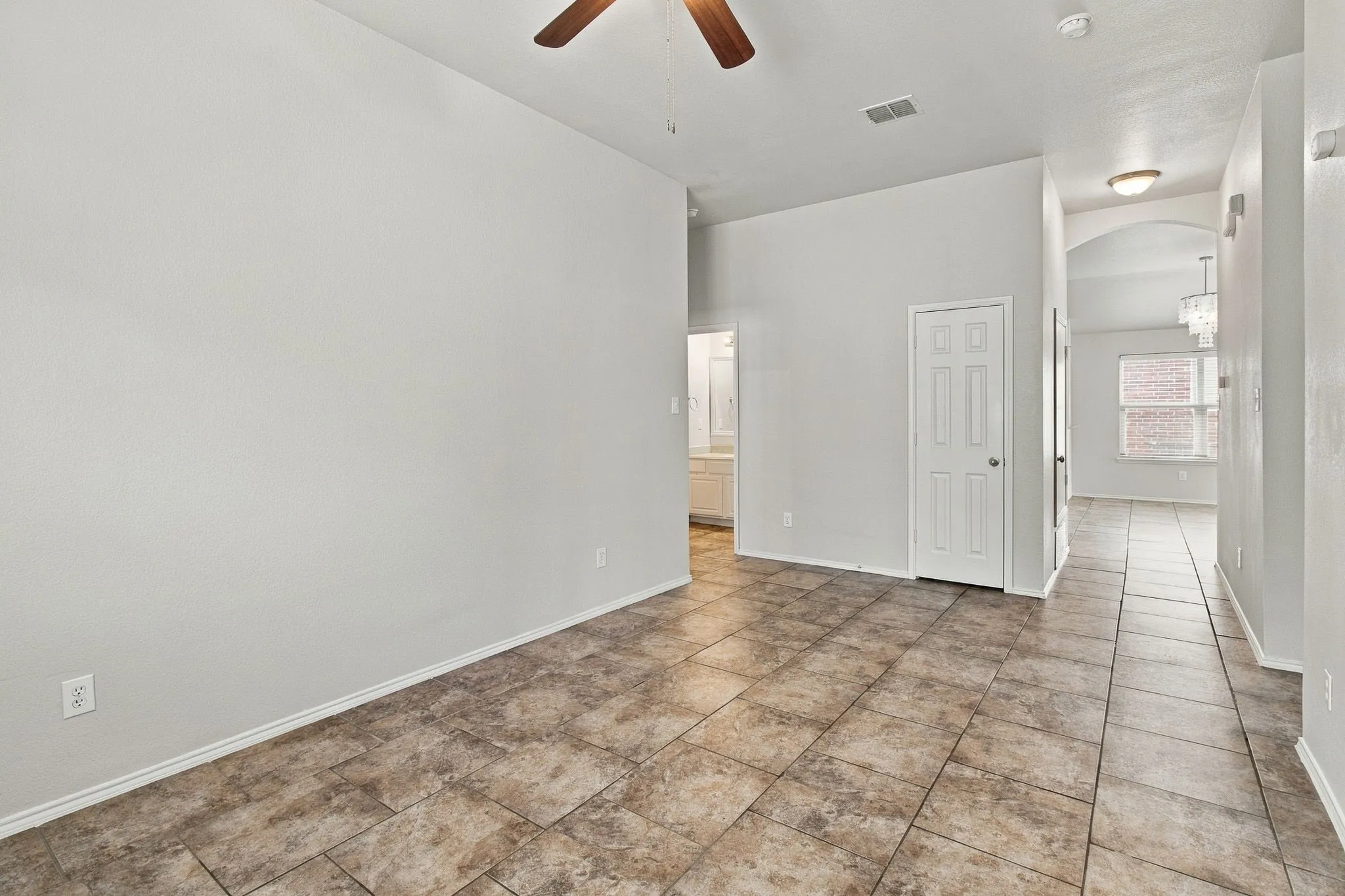 Neutral paint palette with tile flooring, featuring a hallway with an arched doorway