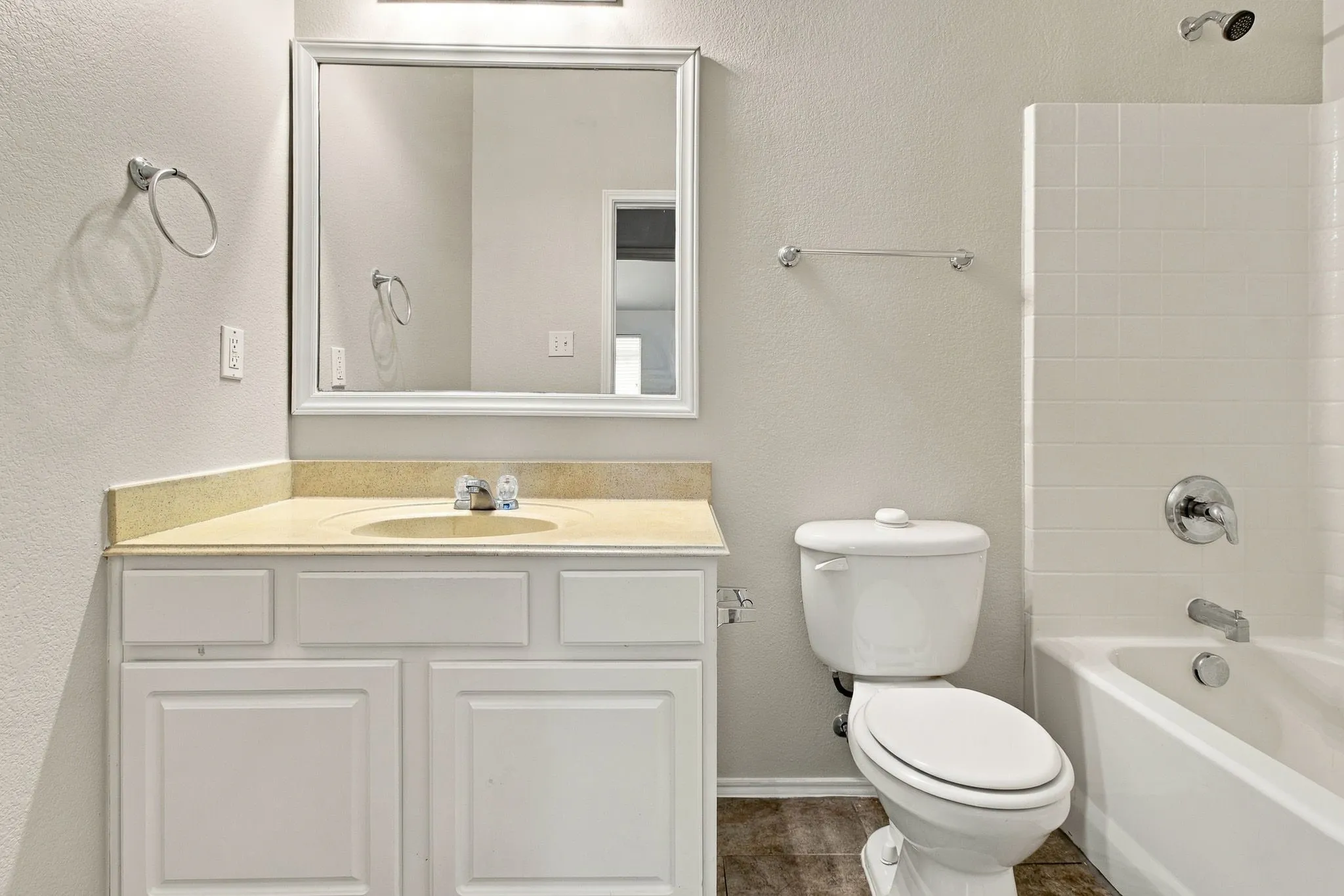 White vanity with a neutral-toned countertop and an undermount sink
