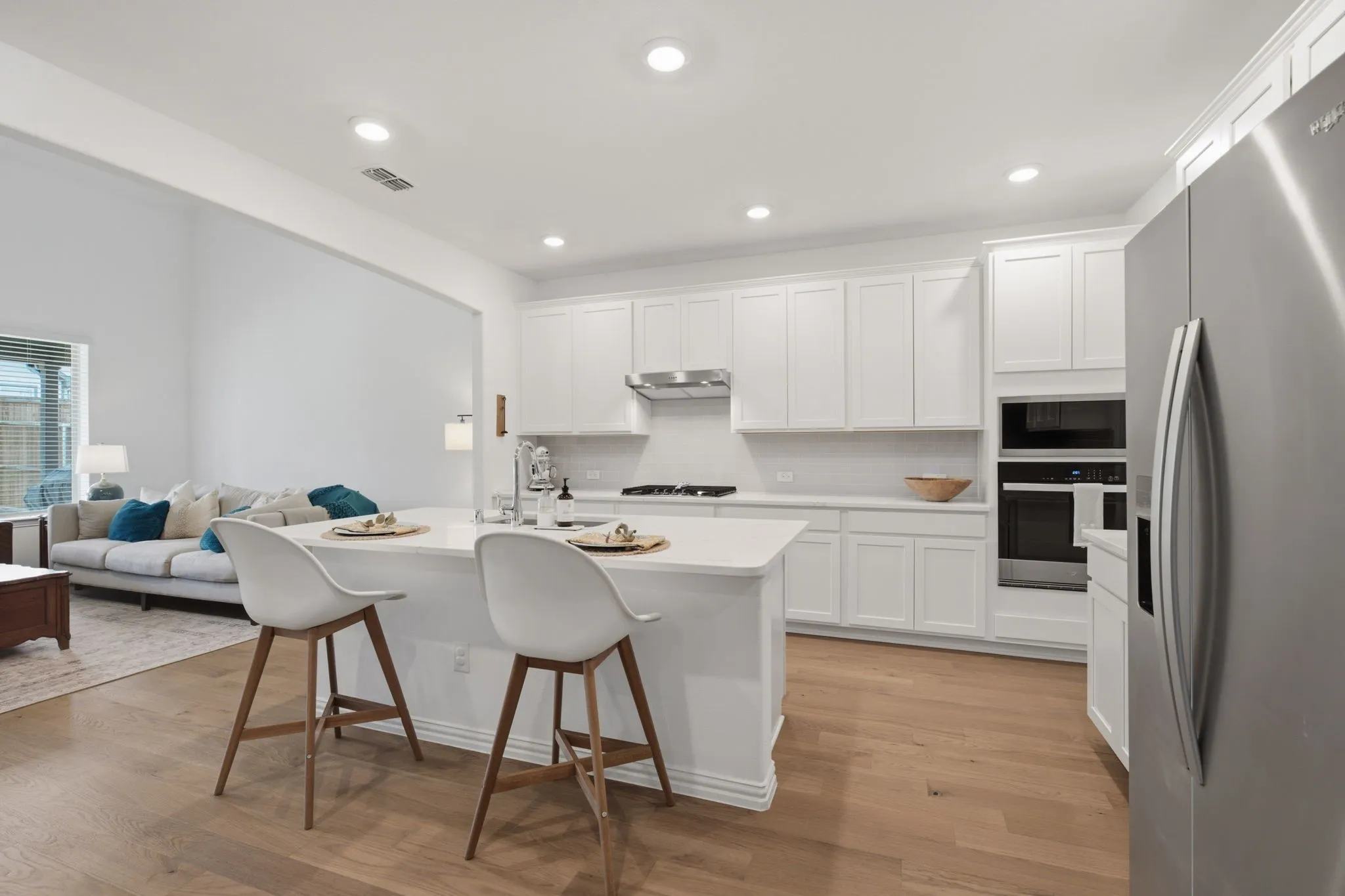 Open-concept kitchen, dining, and living layout filled with natural light and upgraded finishes. This is the modern floorplan buyers want.