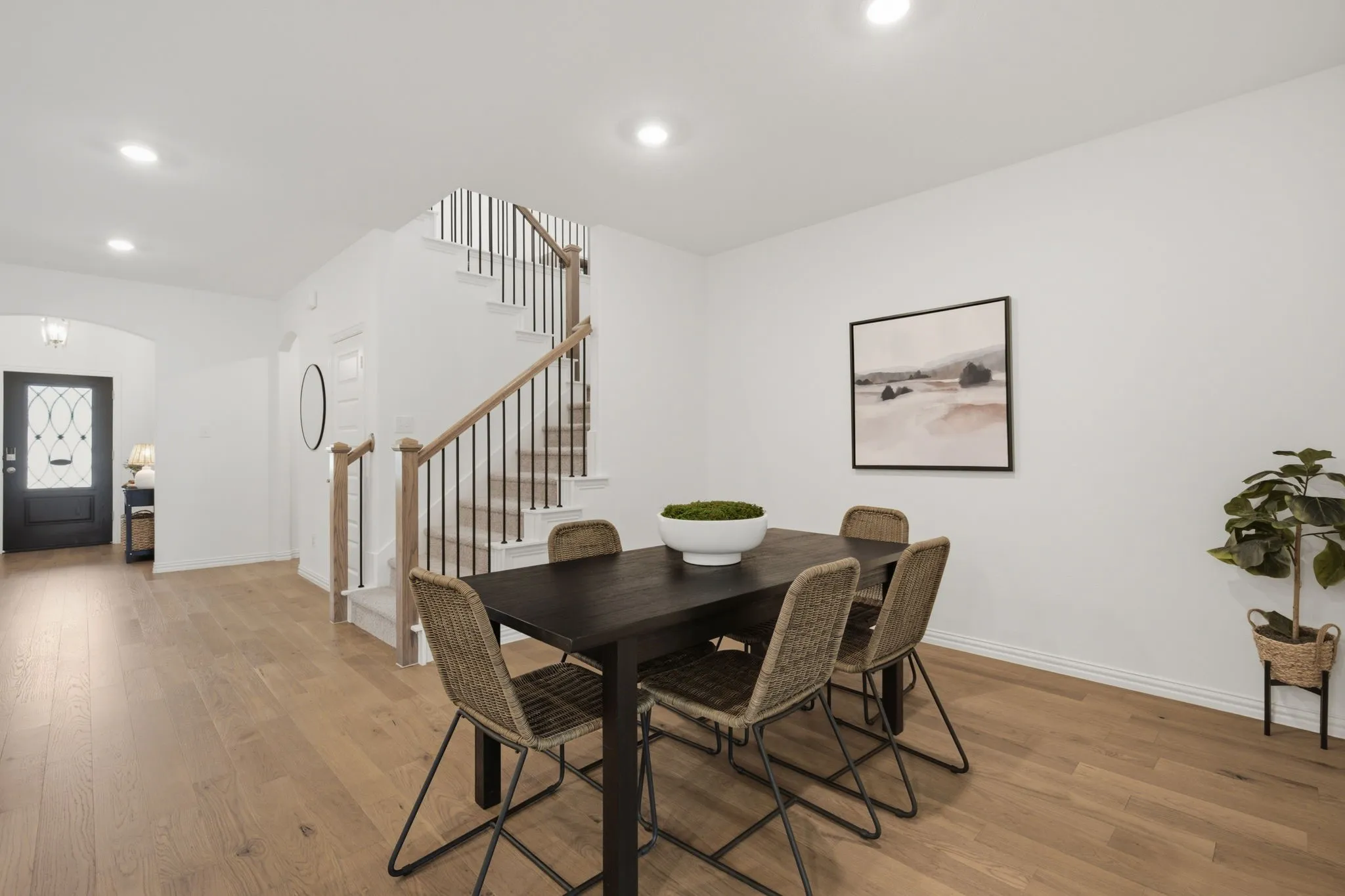 Open dining area with warm wood flooring and seamless flow to the living room and kitchen. Designed for everyday meals, holidays, and entertaining.