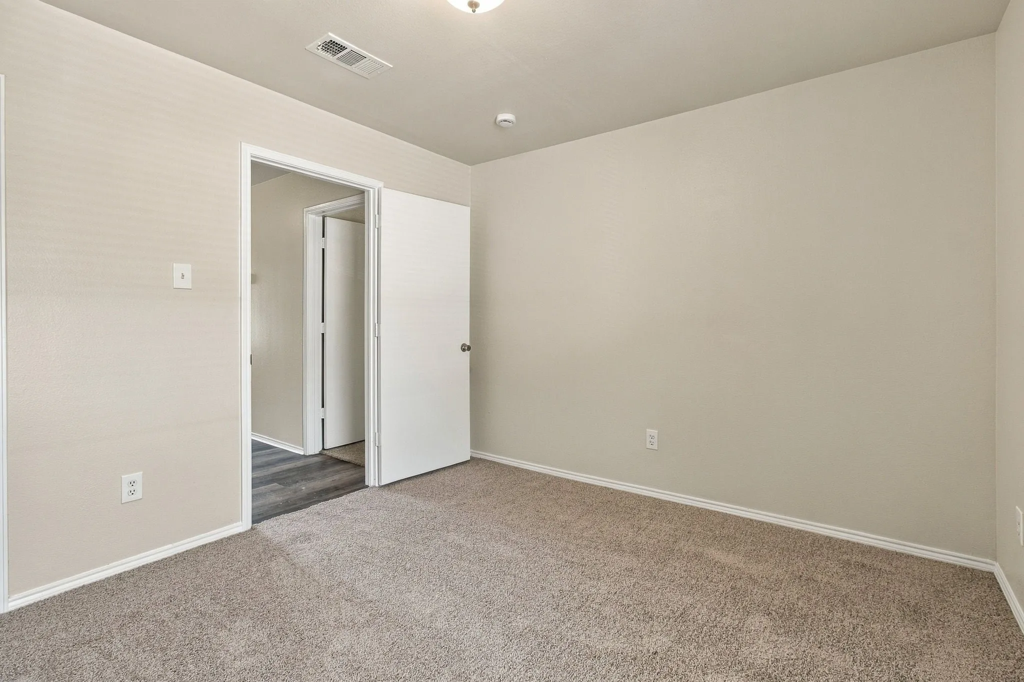 Neutral-toned walls complement the carpeted flooring