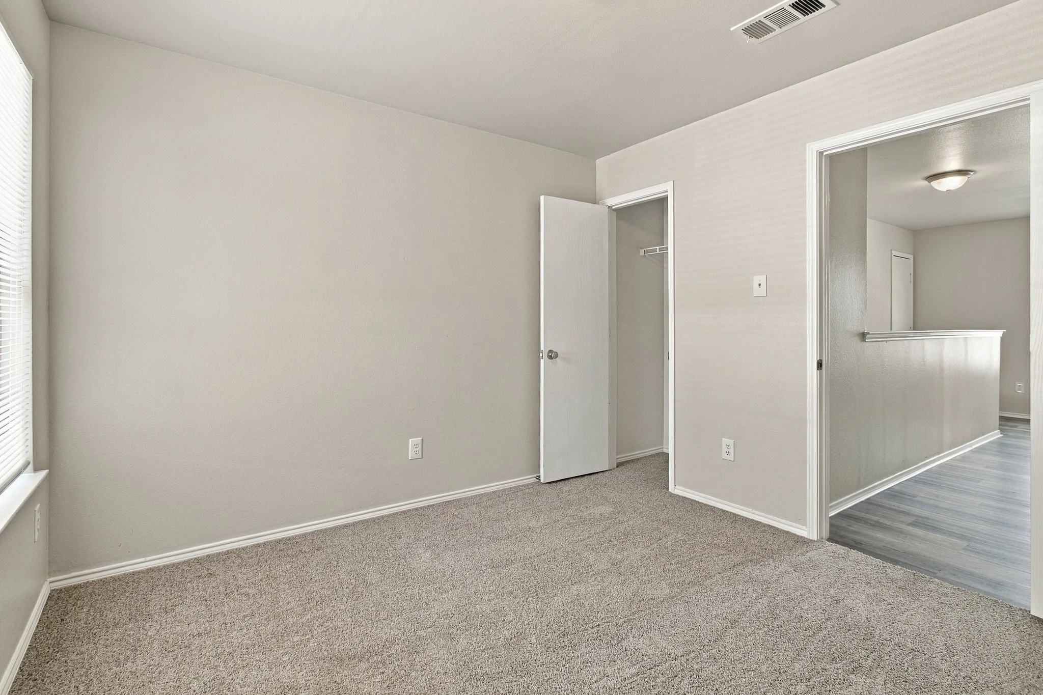 Carpeted flooring, window with blinds, interior door to a closet, and ceiling-mounted light fixture