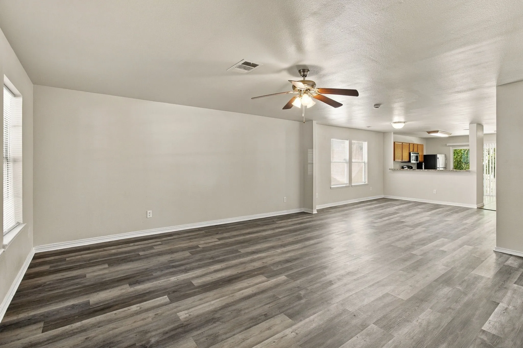 Expansive room featuring wood-finish flooring, neutral wall tones, and recessed lighting