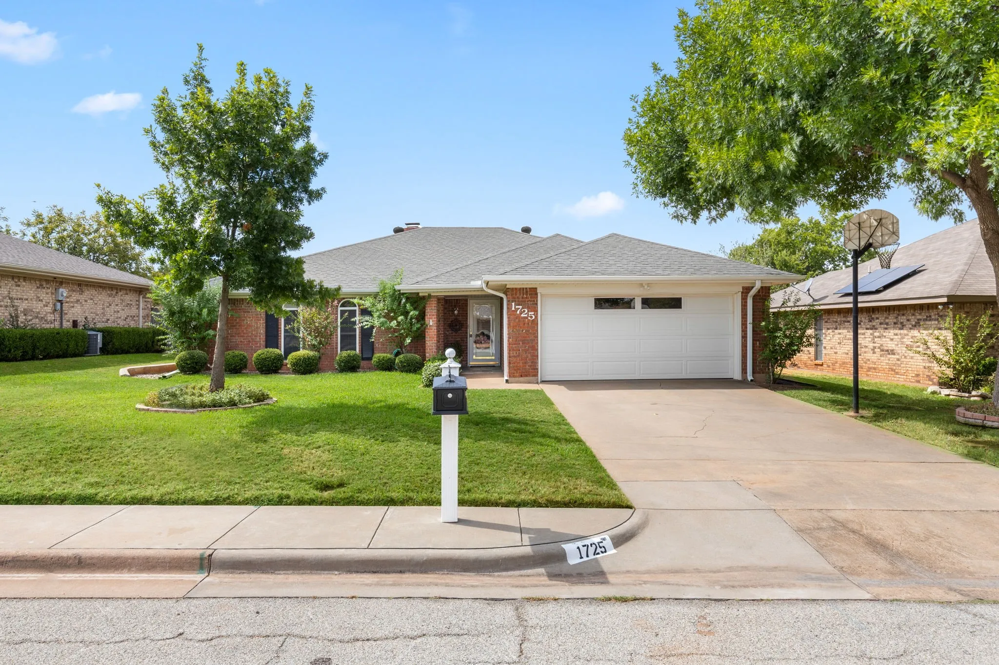 Brick exterior with a gabled roof and a white garage door